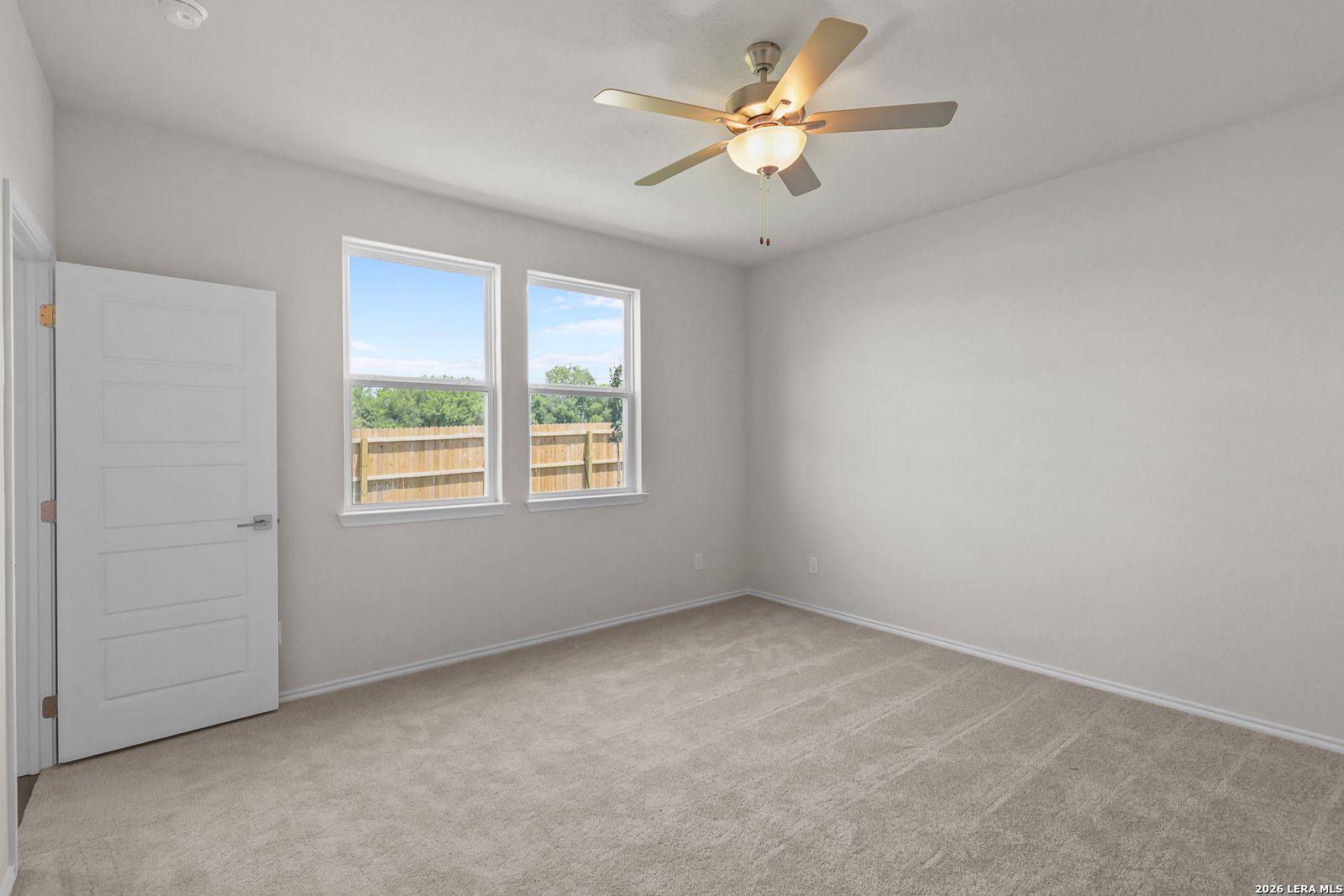 Bright, carpeted bedroom with ceiling fan in The San Marcos F floor plan at Rayburn Valley, San Antonio, Texas.