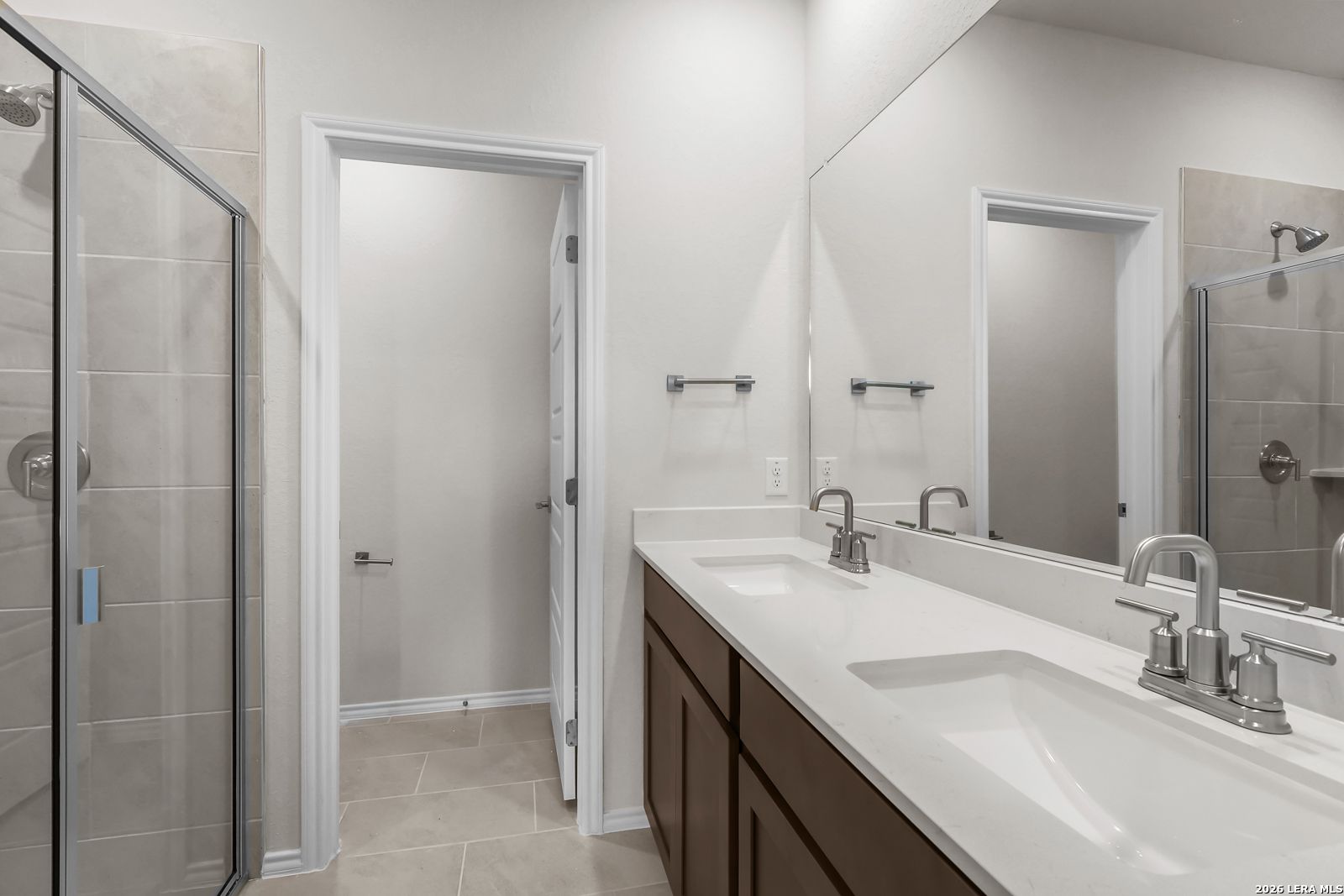 Modern bathroom with double vanity, walk-in shower, and tile flooring in a Davidson Homes San Marcos F floor plan.