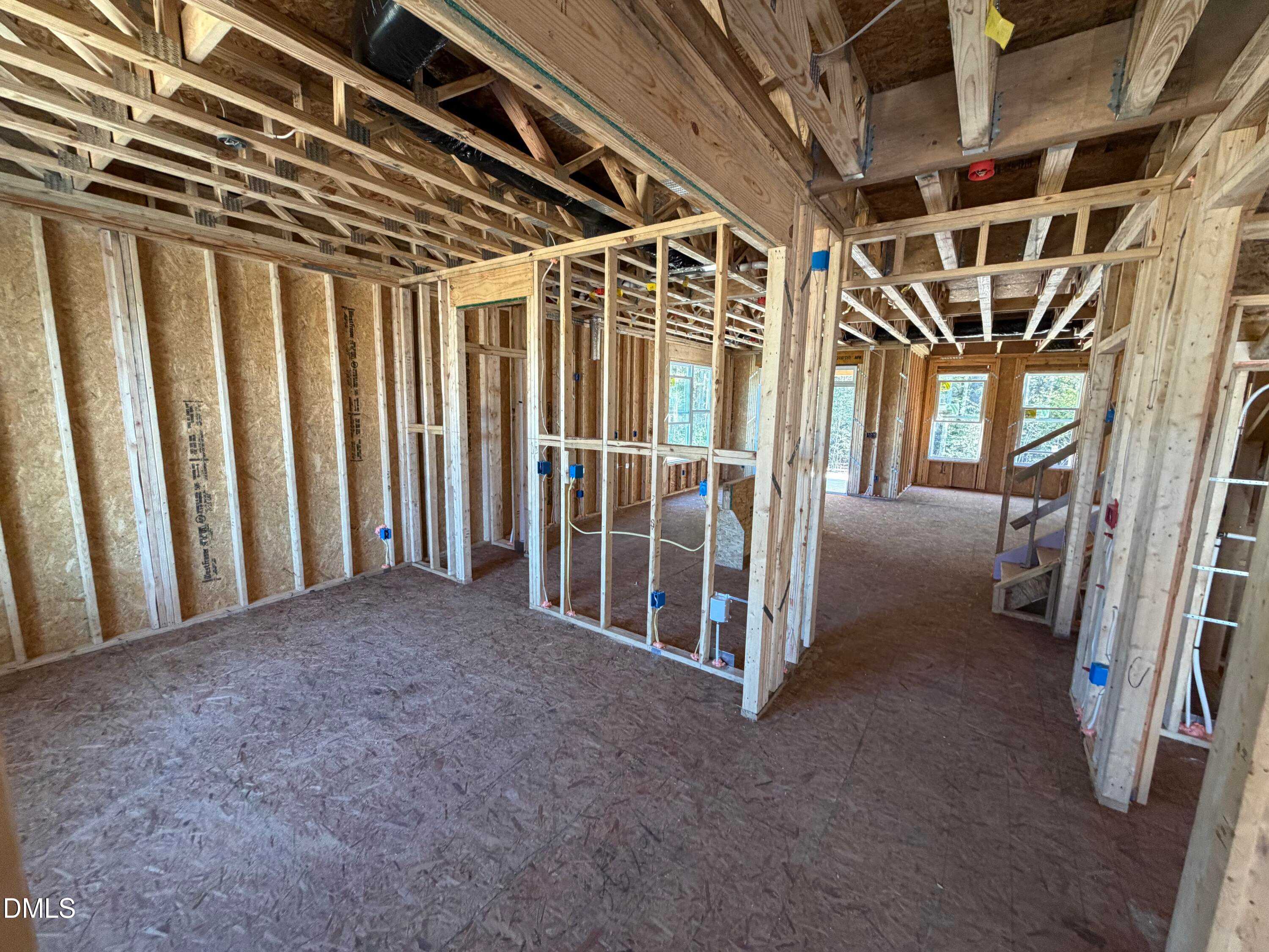Exposed wooden framing reveals open layout, staircase, and room divisions in 2-story 3-bedroom The Ash B home by Davidson Homes, Lillington, NC