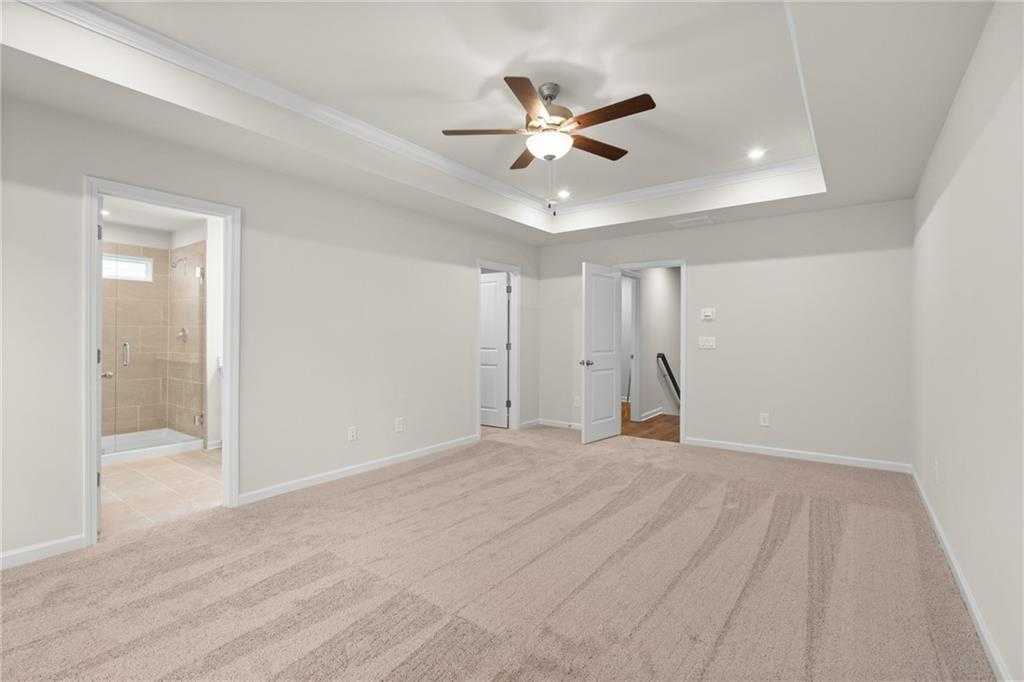 Spacious master bedroom with ceiling fan, en-suite bath, and walk-in closet in Davidson Homes The Marion B, Kennesaw, Georgia