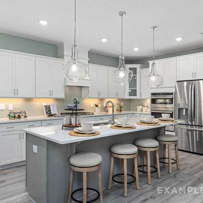 Modern open-concept kitchen in Windgate, Mooresville NC with white shaker cabinets, gray island, bar stools, stainless steel appliances, and hardwood floors
