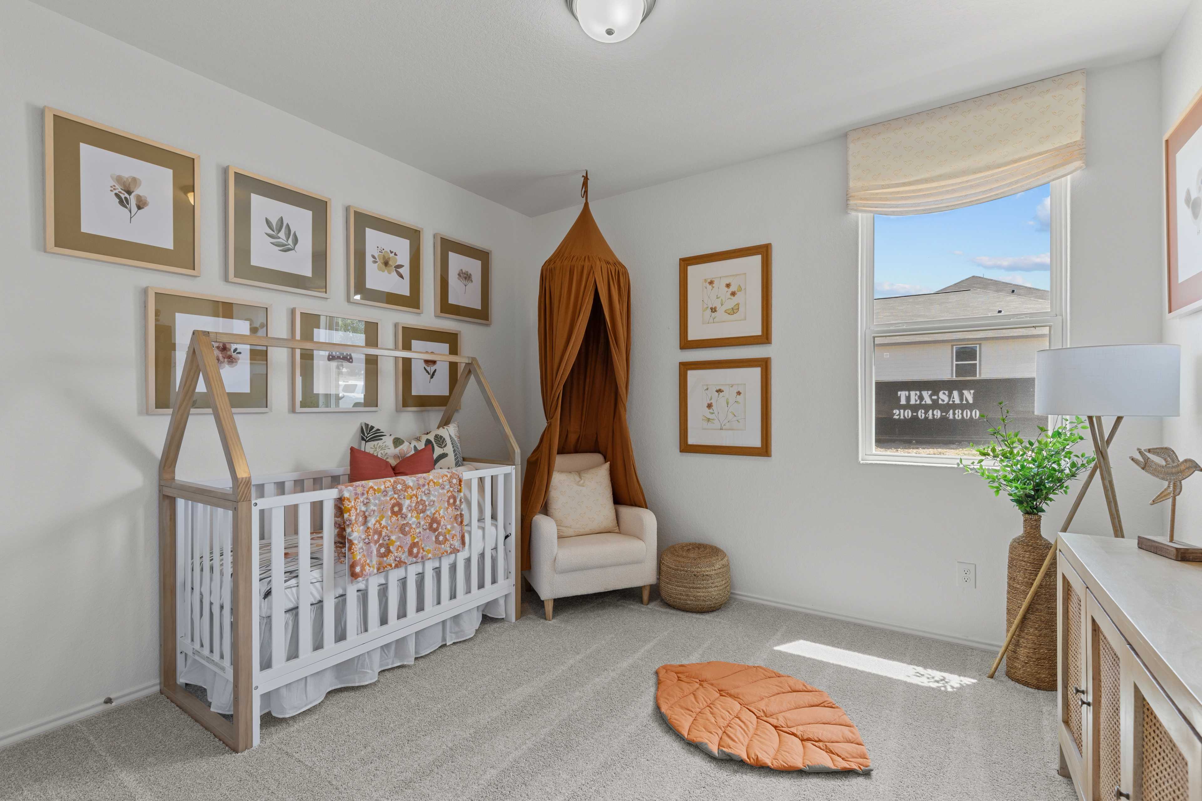 Cozy nursery in The Daphne H home design with white crib, teepee canopy, floral bedding, botanical art, armchair, and leaf rug