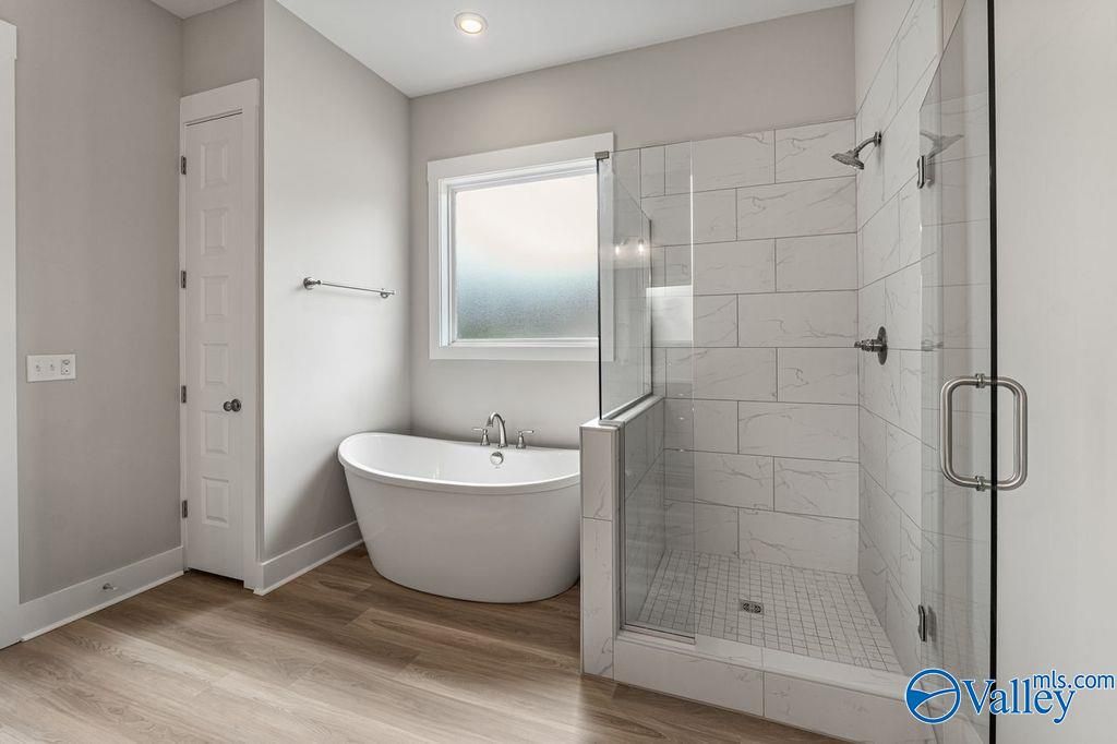 Elegant master bath with freestanding tub, glass shower, subway tiles in Evermore Homes The Oxford, Owens Cross Roads, AL