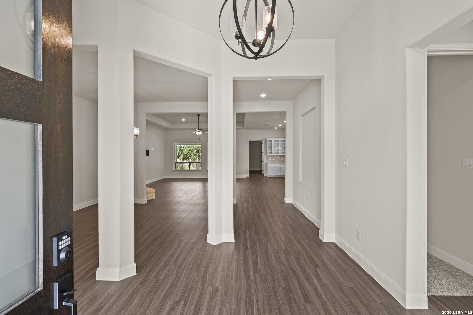 Bright foyer with modern orb chandelier and wood-look flooring in The Summerlin B floor plan, Potranco Oaks, Castroville.