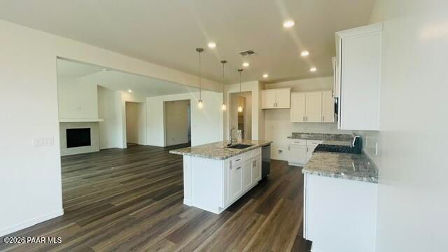 Open-concept kitchen with white cabinets and granite island in The Summit A floor plan, Westwood, Prescott, Arizona.