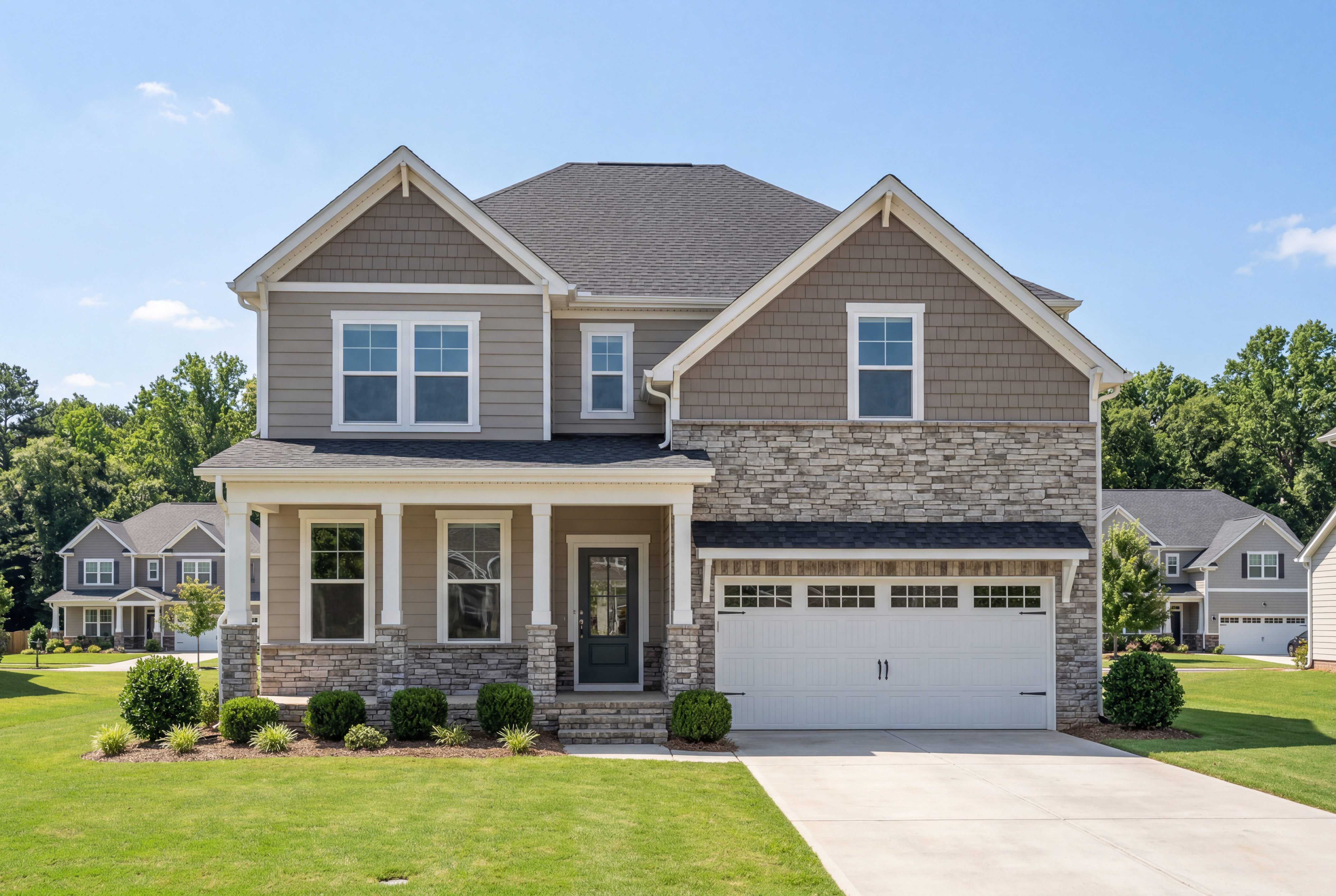 Two-story Hemlock D home elevation with stone and siding exterior, covered front porch, two-car garage, and landscaped yard in Belmont NC