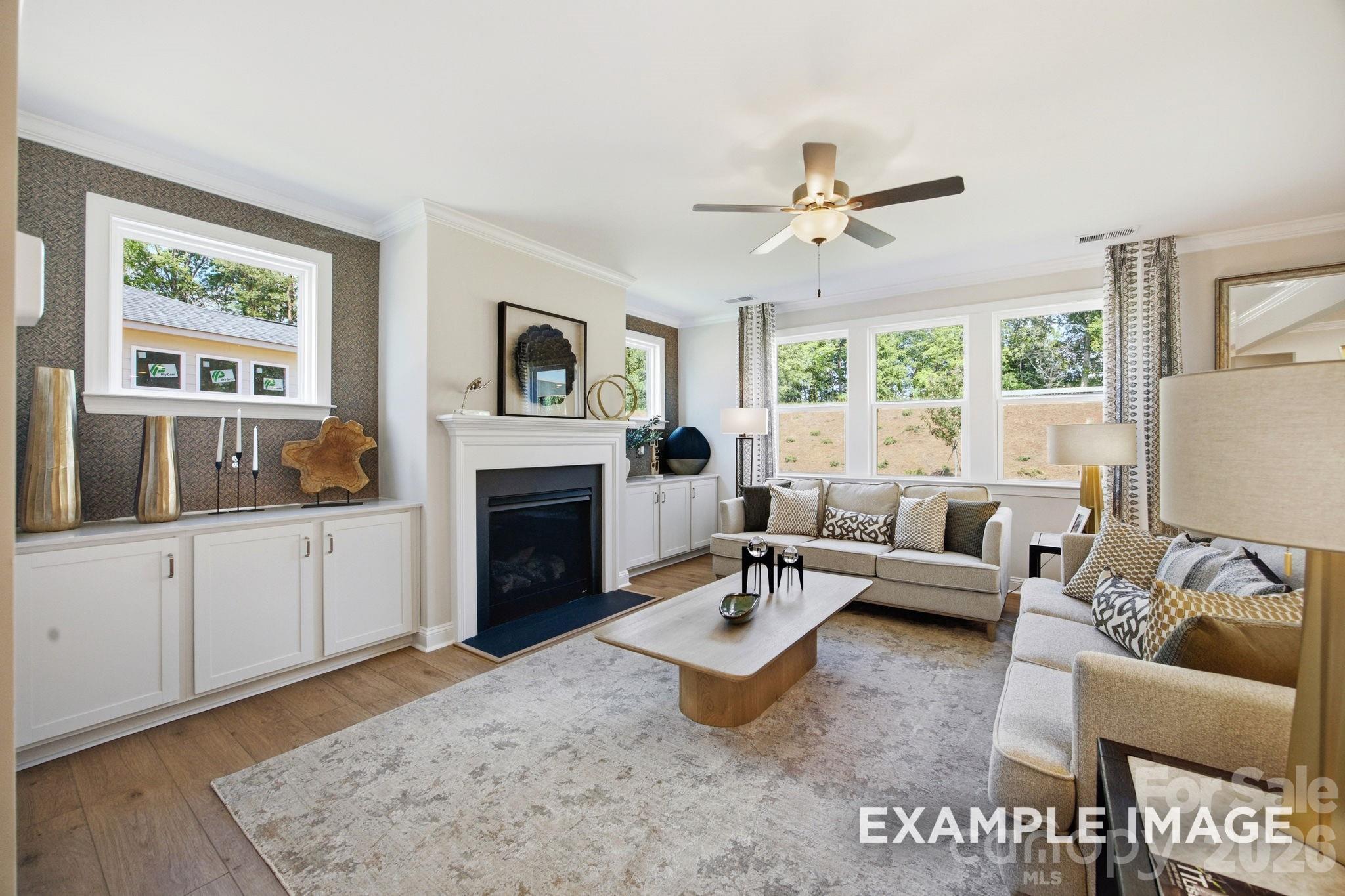 Bright living room with fireplace and built-in cabinets in The Hickory D II floor plan, Windgate, Mooresville, North Carolina.