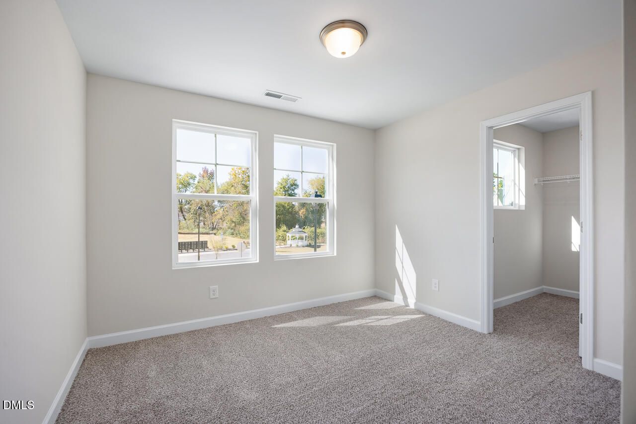 Bright secondary bedroom with beige carpet, large windows, and natural light in Davidson Homes The Grace C, Lillington, NC