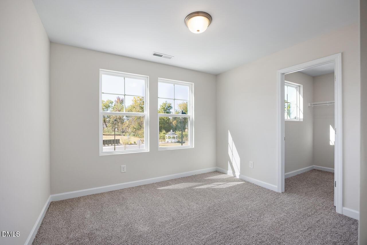 Bright secondary bedroom with beige carpet, large windows, and natural light in Davidson Homes The Grace C, Lillington, NC