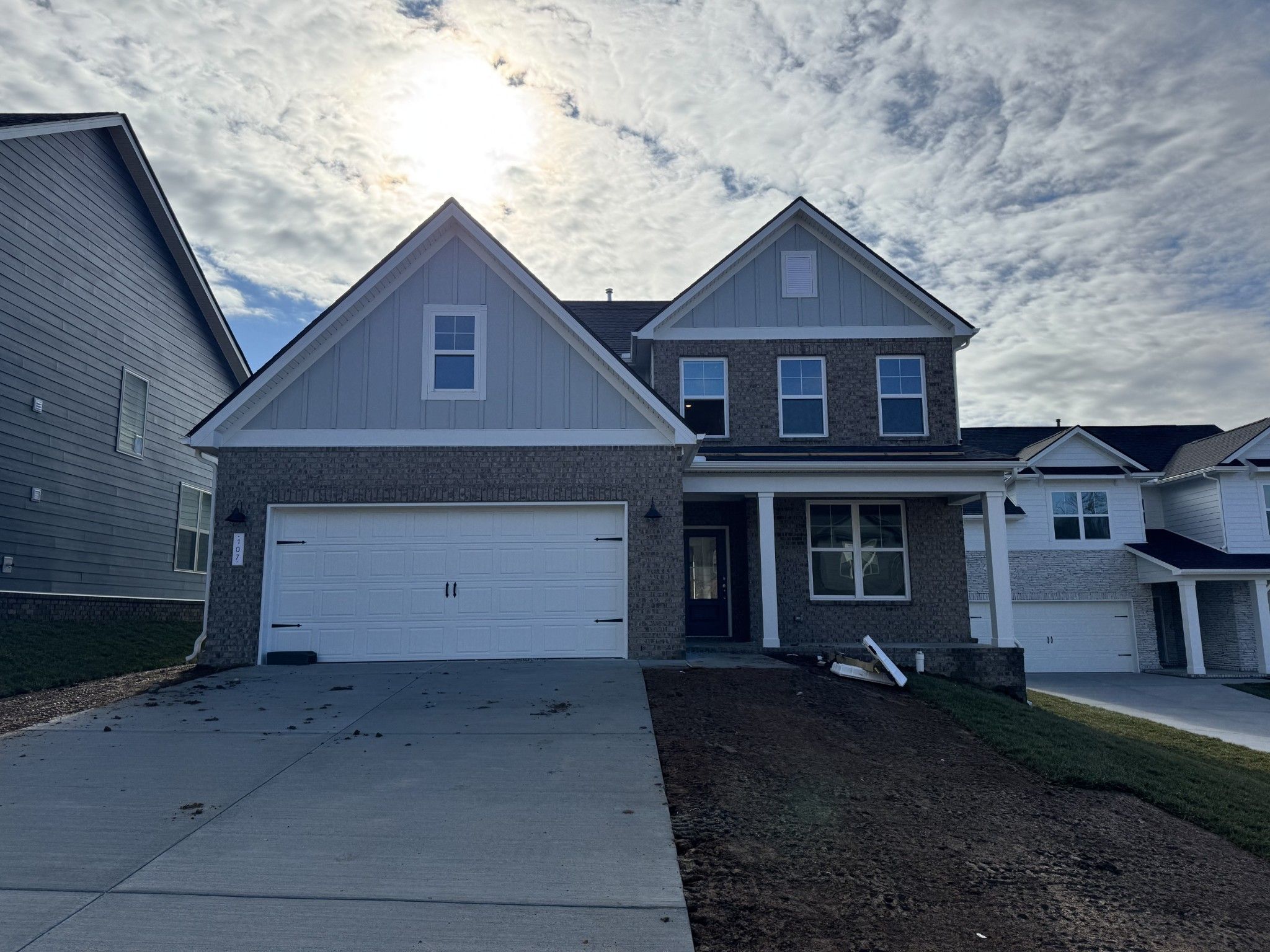 Modern 2-story The Ash A home by Davidson Homes with brick accents, 2-car garage, and front porch in Woods Crossing, Gallatin, TN