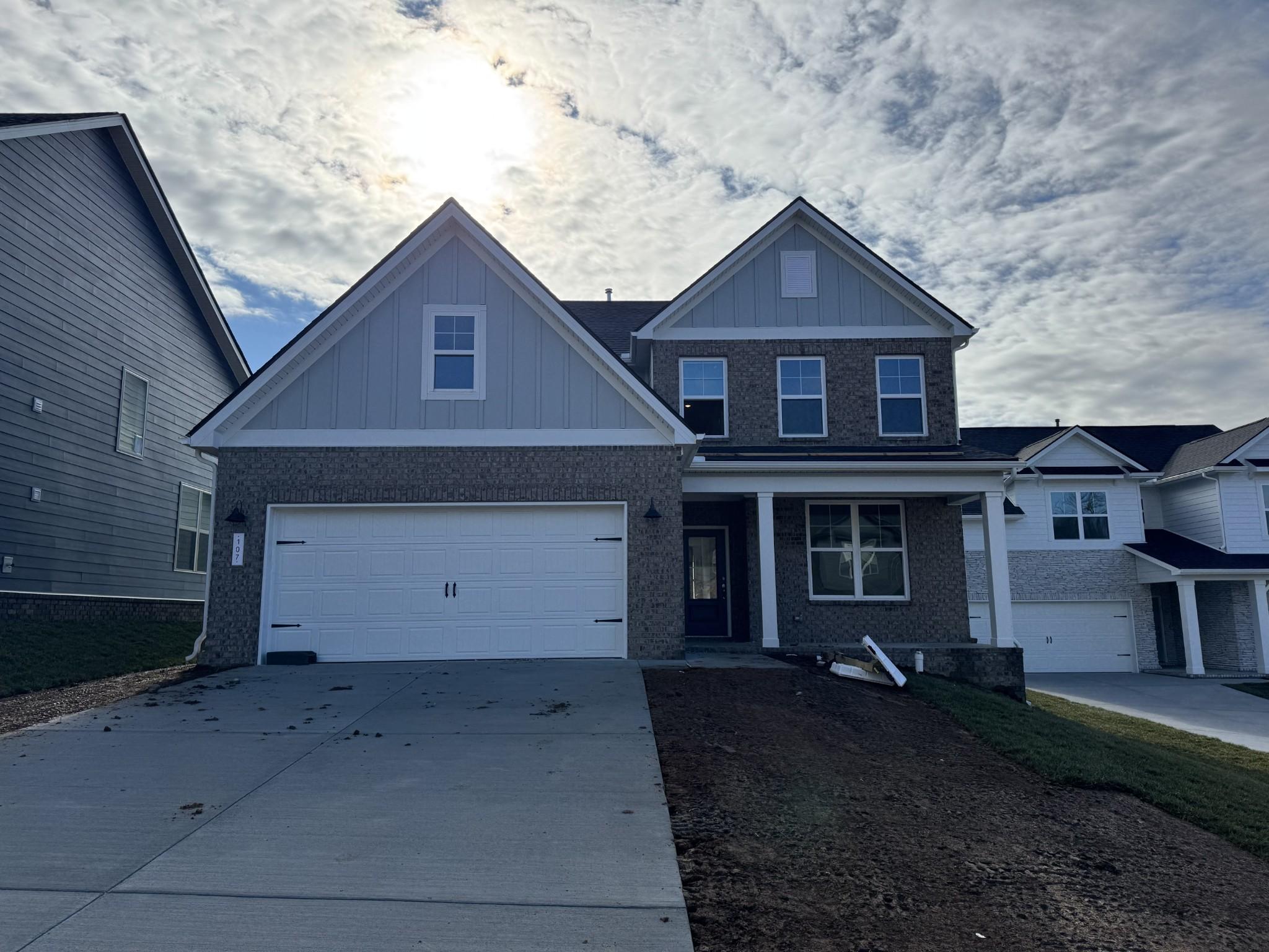 Modern 2-story The Ash A home by Davidson Homes with brick accents, 2-car garage, and front porch in Woods Crossing, Gallatin, TN