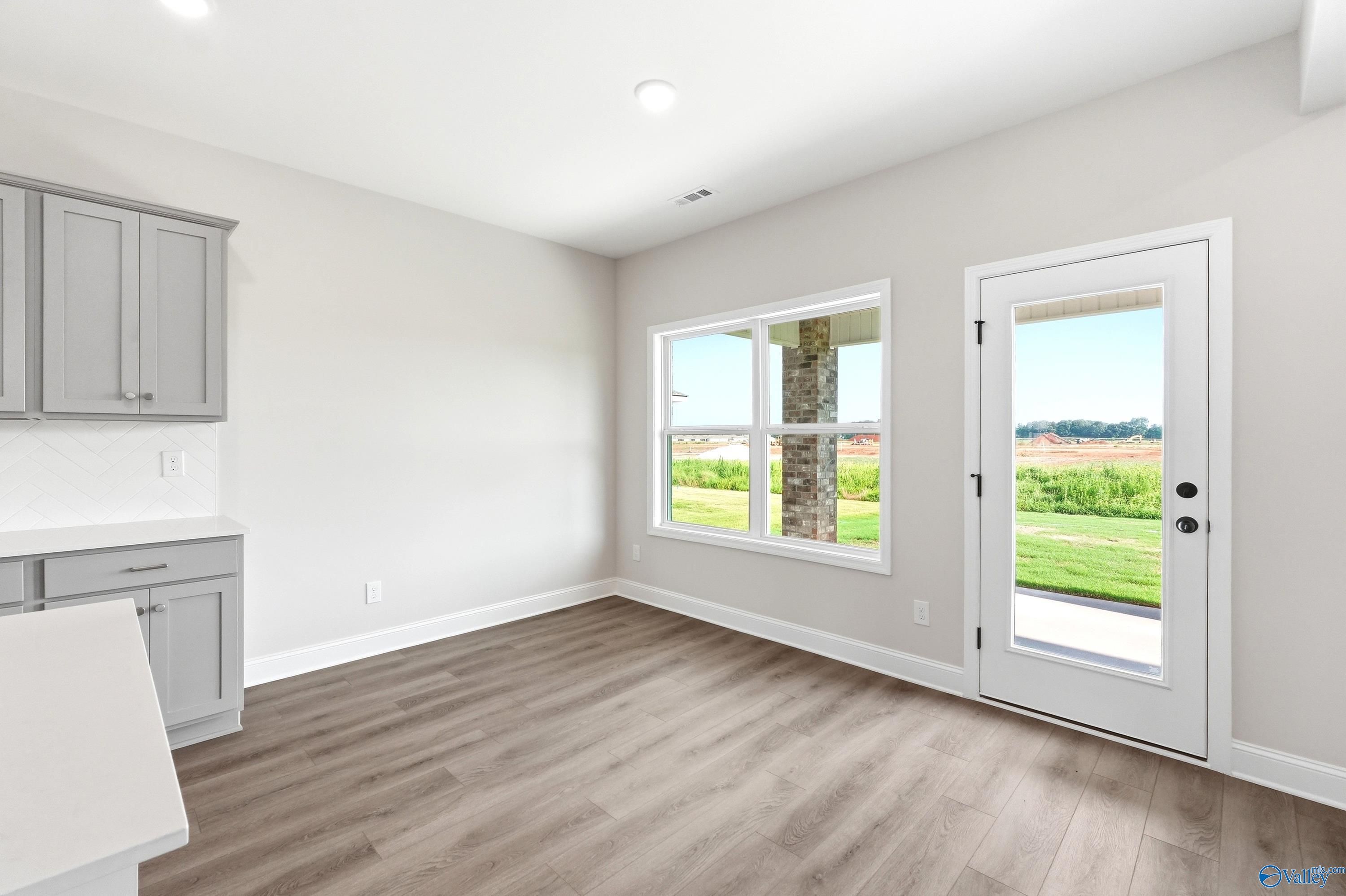 Bright breakfast nook with gray cabinets and patio access in The Shelby A floor plan, Clearview, Hazel Green, Alabama.