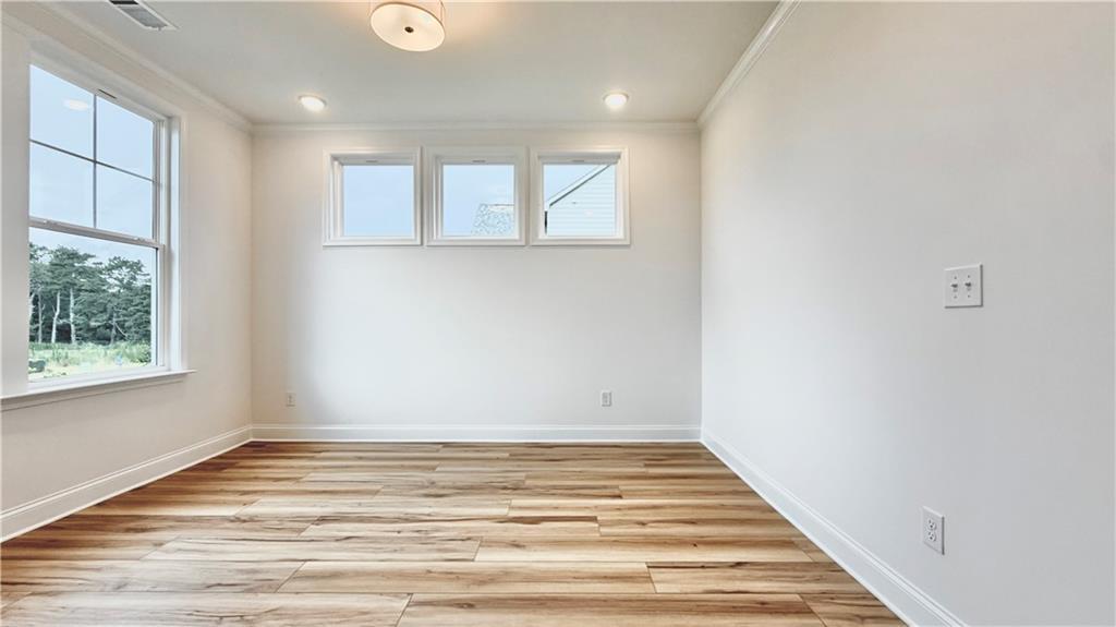 Bright, sunlit room with wood-look flooring in The Glenwood A floor plan at Wehunt Meadows, Hoschton, Georgia.
