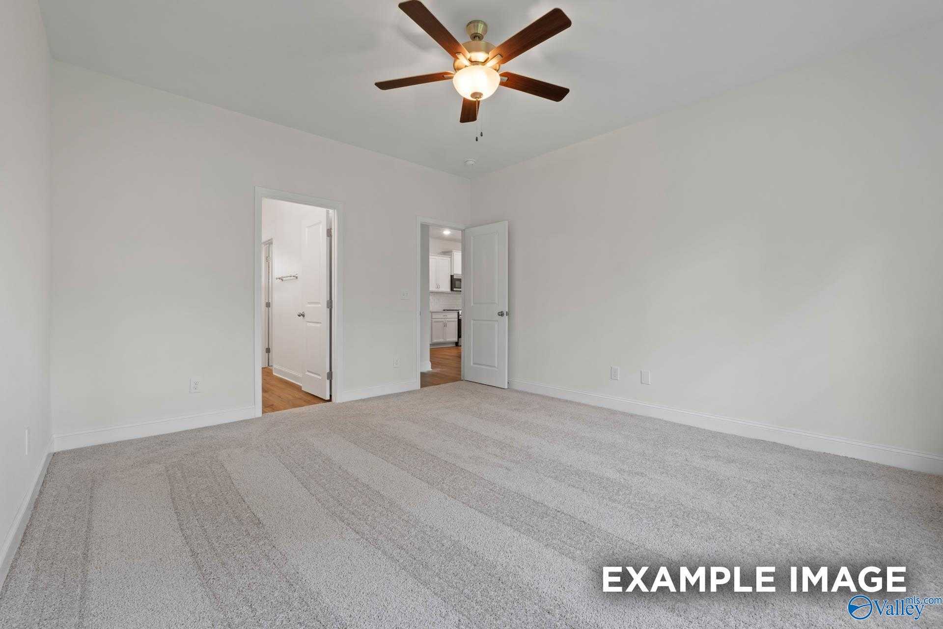 Spacious bedroom with ceiling fan, carpet flooring, and attached bath in Davidson Homes The Daphne D, Athens AL