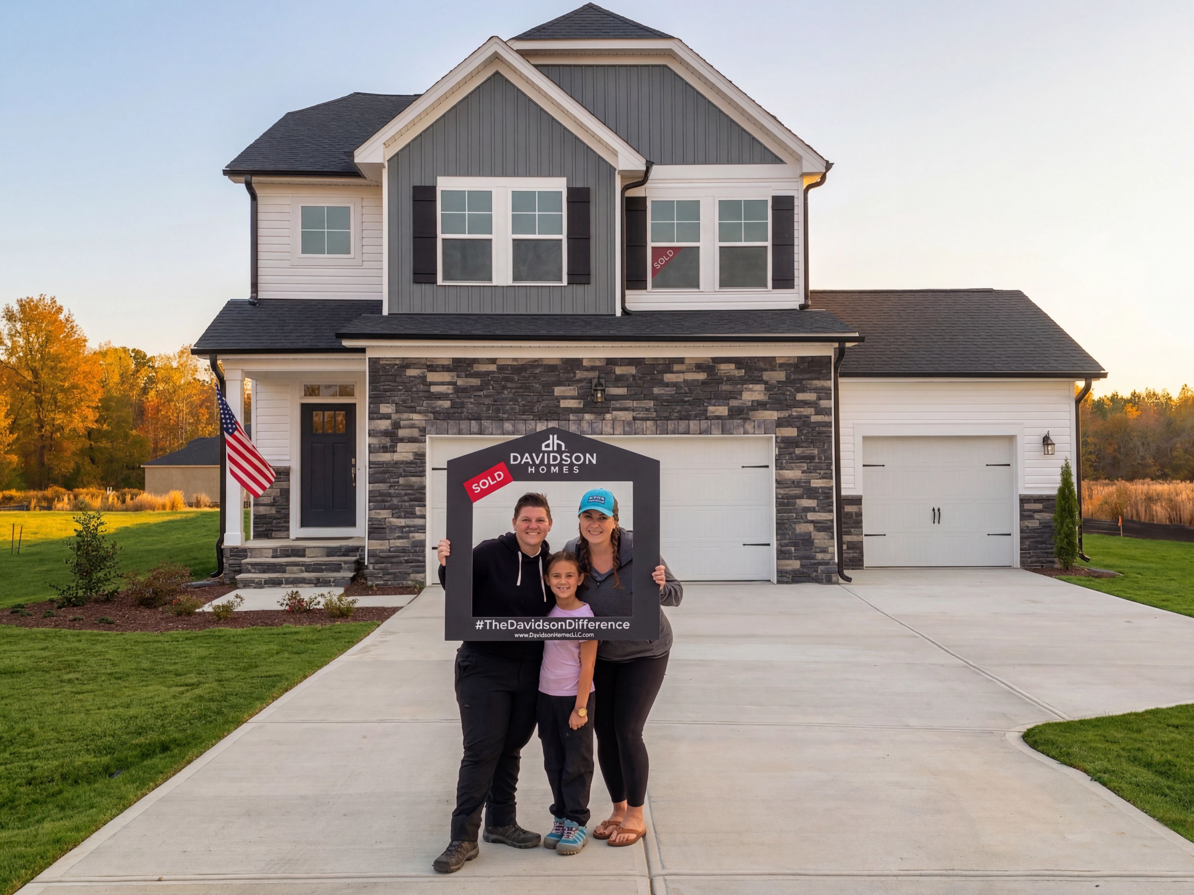 Raleigh homeowners holding a Davidson Homes sold sign in front of their new home in the Triangle.