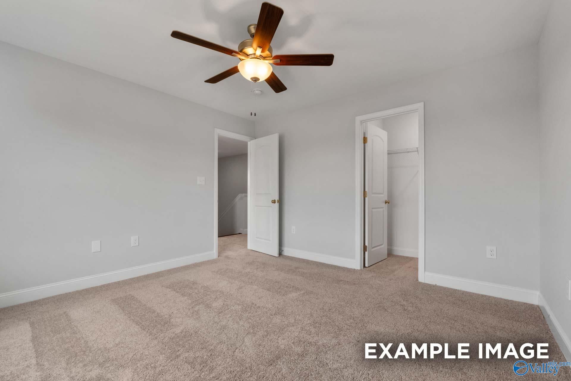 Spacious secondary bedroom with ceiling fan, walk-in closet, and adjacent bath in 4-bedroom Davidson Homes The Shelby C, Arab, Alabama