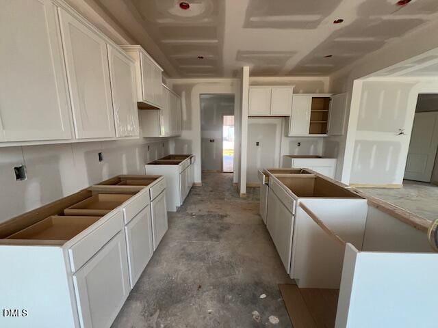 Under-construction kitchen with white cabinets and center island in The Gavin C floor plan at Gregory Village, Lillington, NC.
