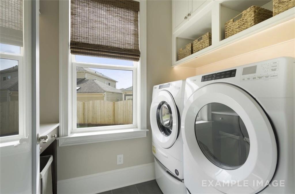 Modern laundry room with white front-load washer, dryer, utility sink, bamboo blinds, and basket shelves in Davidson Homes The Seaside A, Woodstock, GA