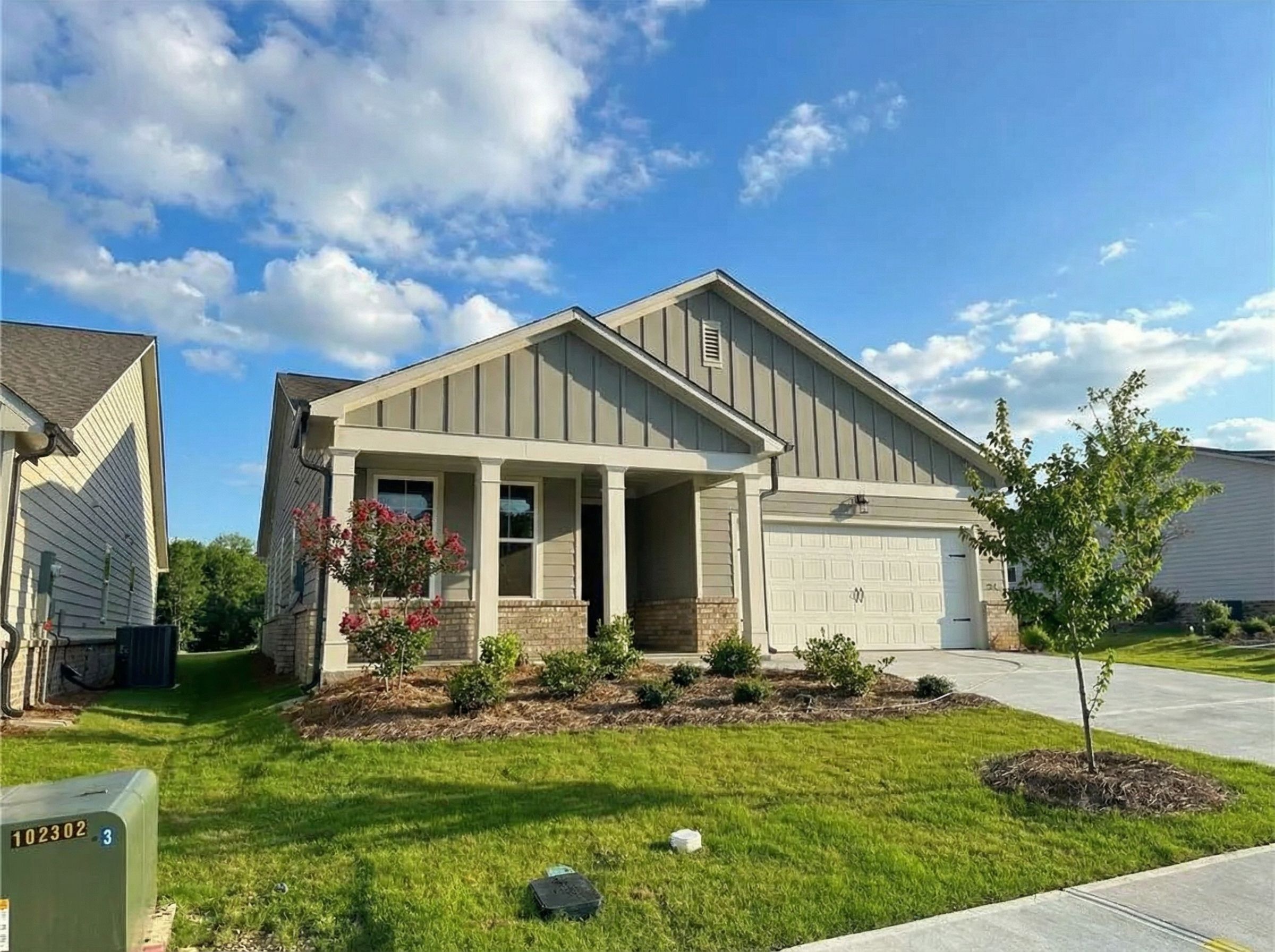 Modern single-story 3-bedroom home with 2-car garage, front porch, and landscaped yard in Kelly Preserve, Loganville, Georgia by Davidson Homes The Edison B