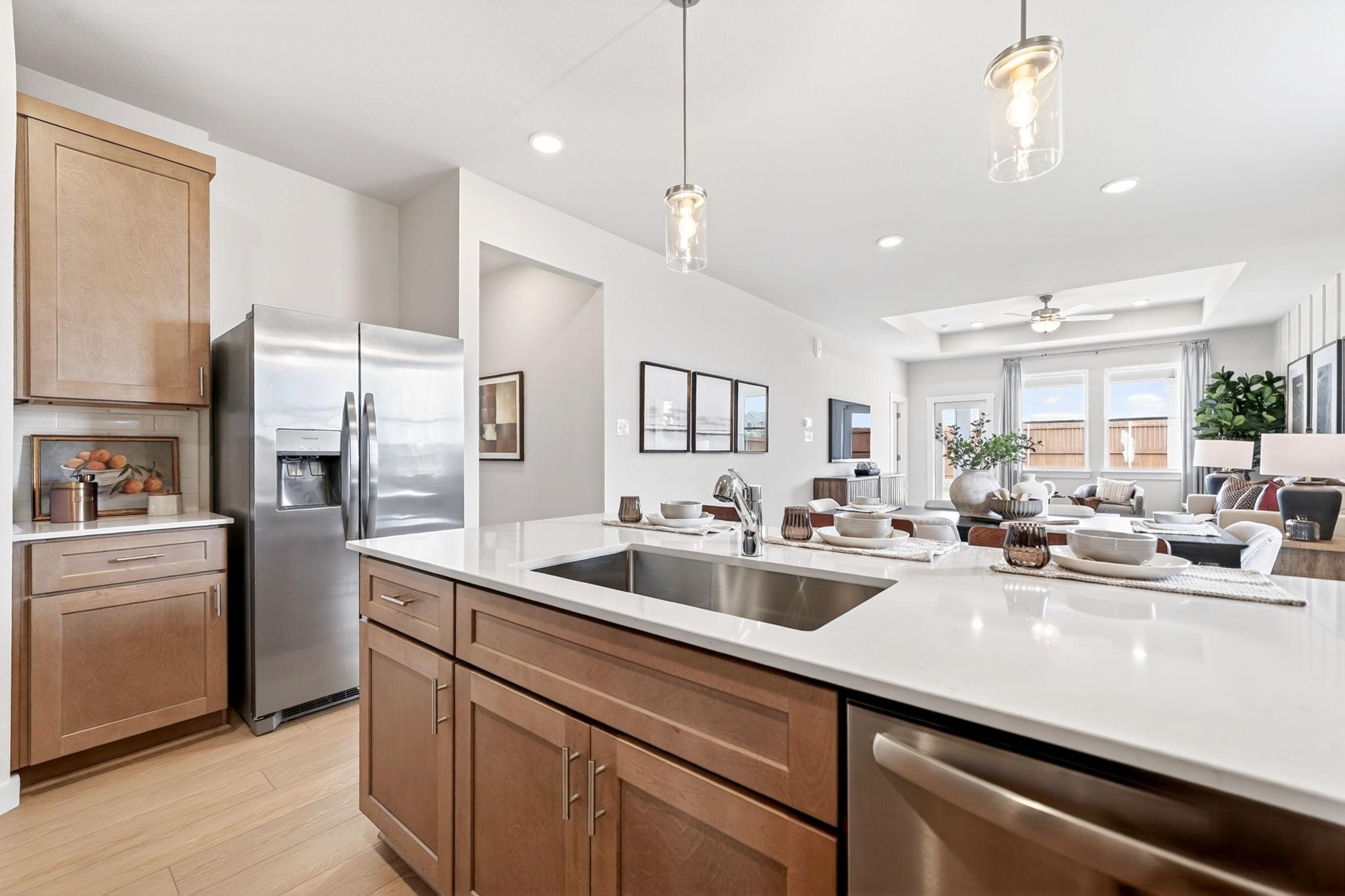 Modern kitchen with white quartz island, stainless steel appliances, and open-concept layout at Mesa Vista in San Antonio.