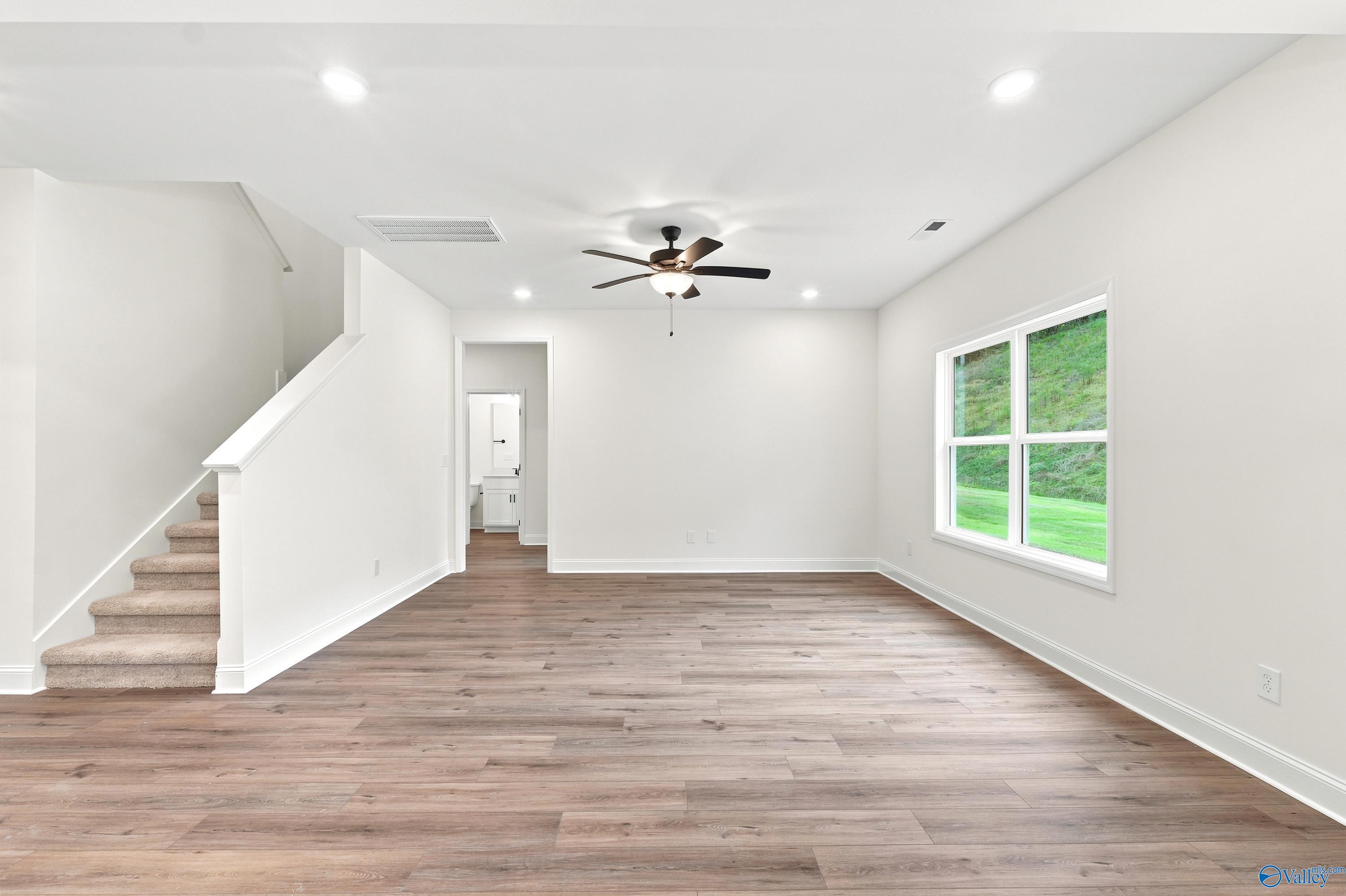 Bright, open-concept living area with wood-style flooring in The Shelby D floor plan at Noble Ridge, Cullman, Alabama.