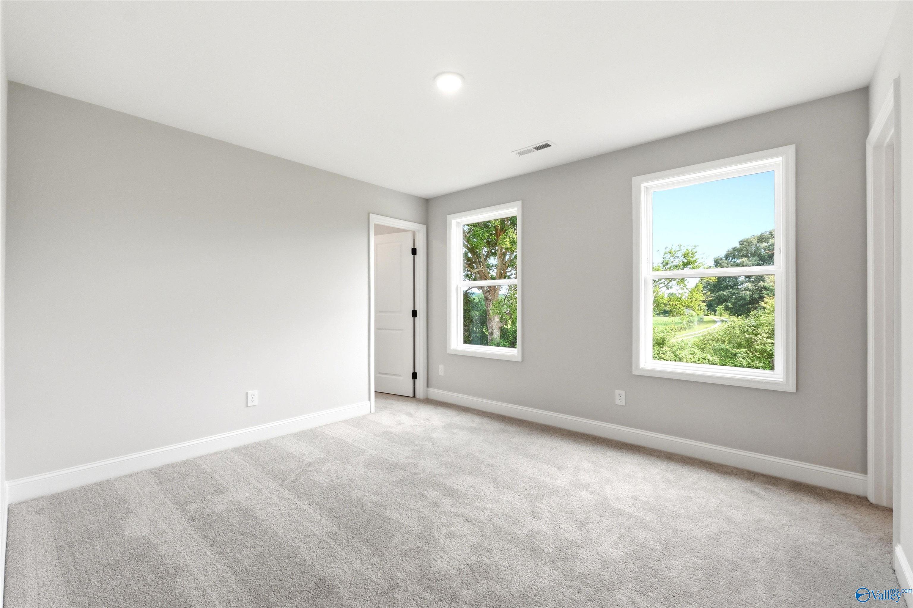 Bright, spacious bedroom with neutral carpet and natural light in The Chelsea D floor plan, Berry Cove, New Market, AL.