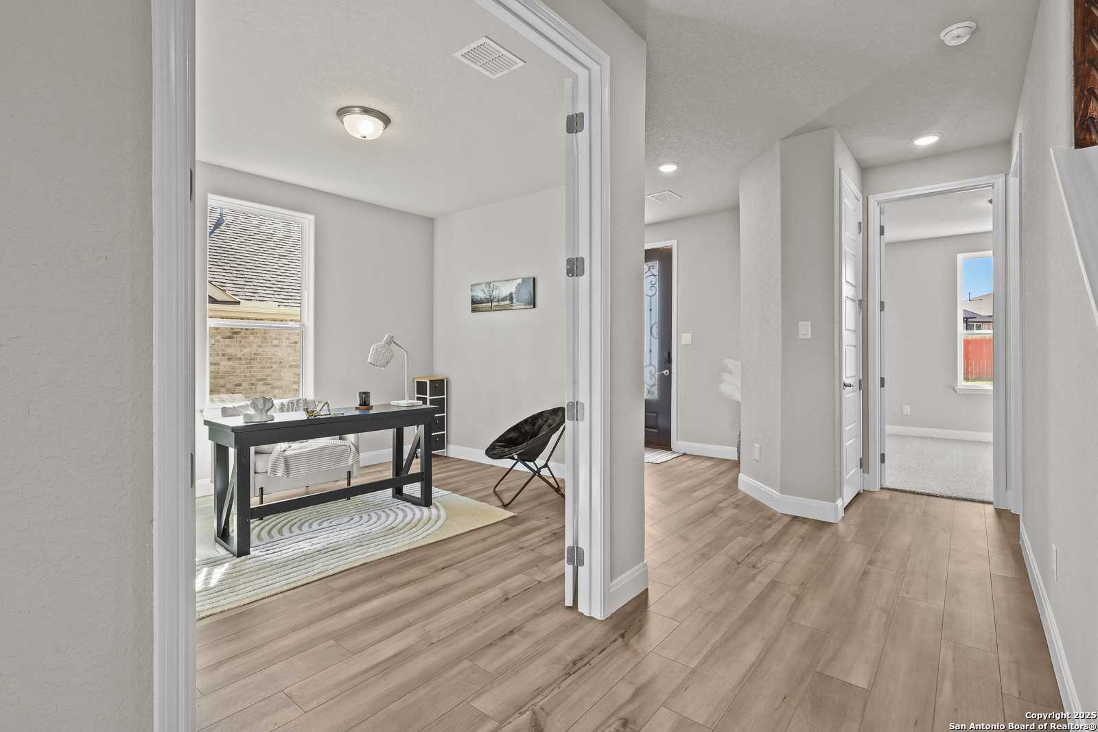 Cozy home office with wooden desk, lamp and open doors in The Jennings G floor plan by Davidson Homes, Castroville, Texas