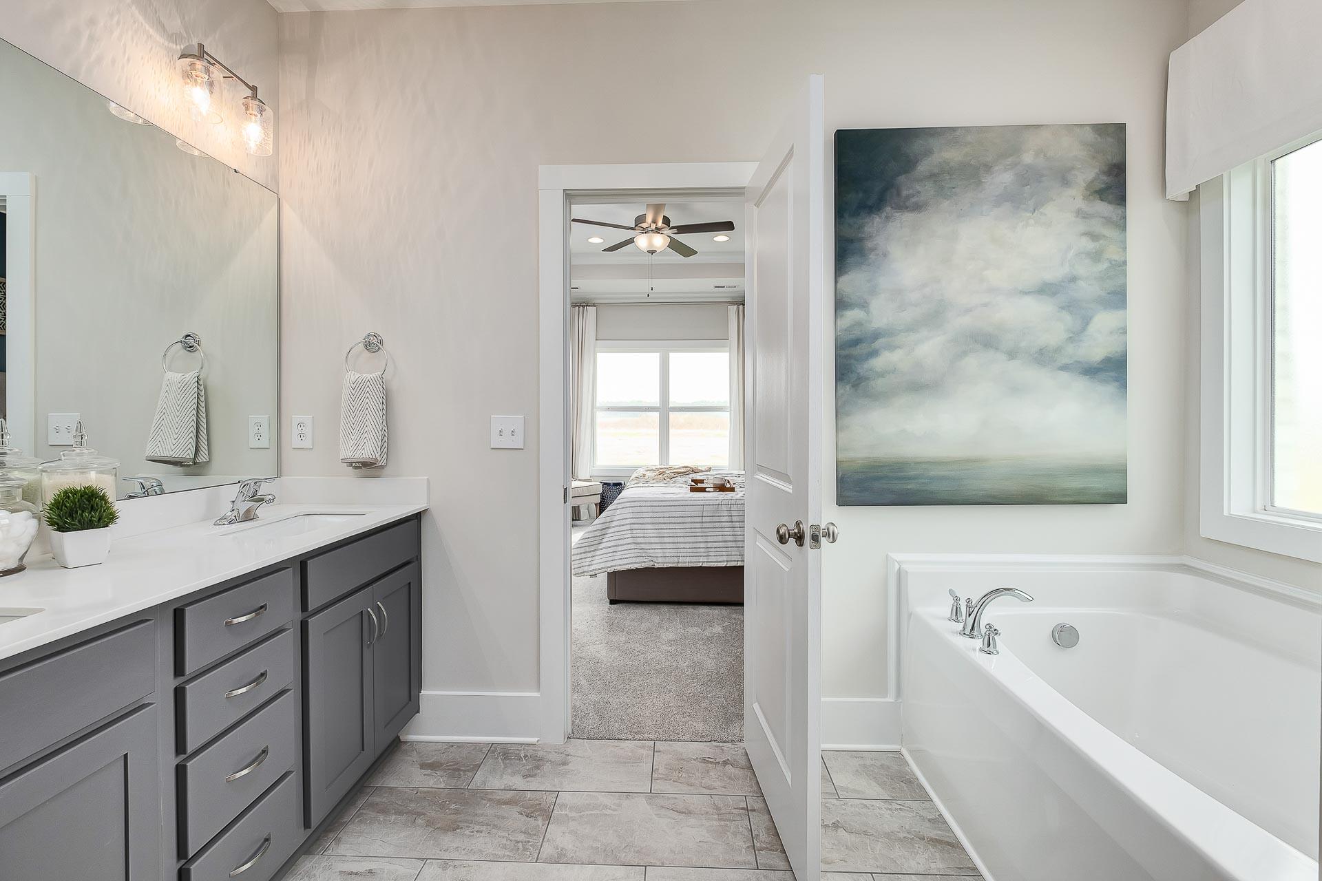 owner's bathroom with gray cabinets and soaking tub by Davidson Homes