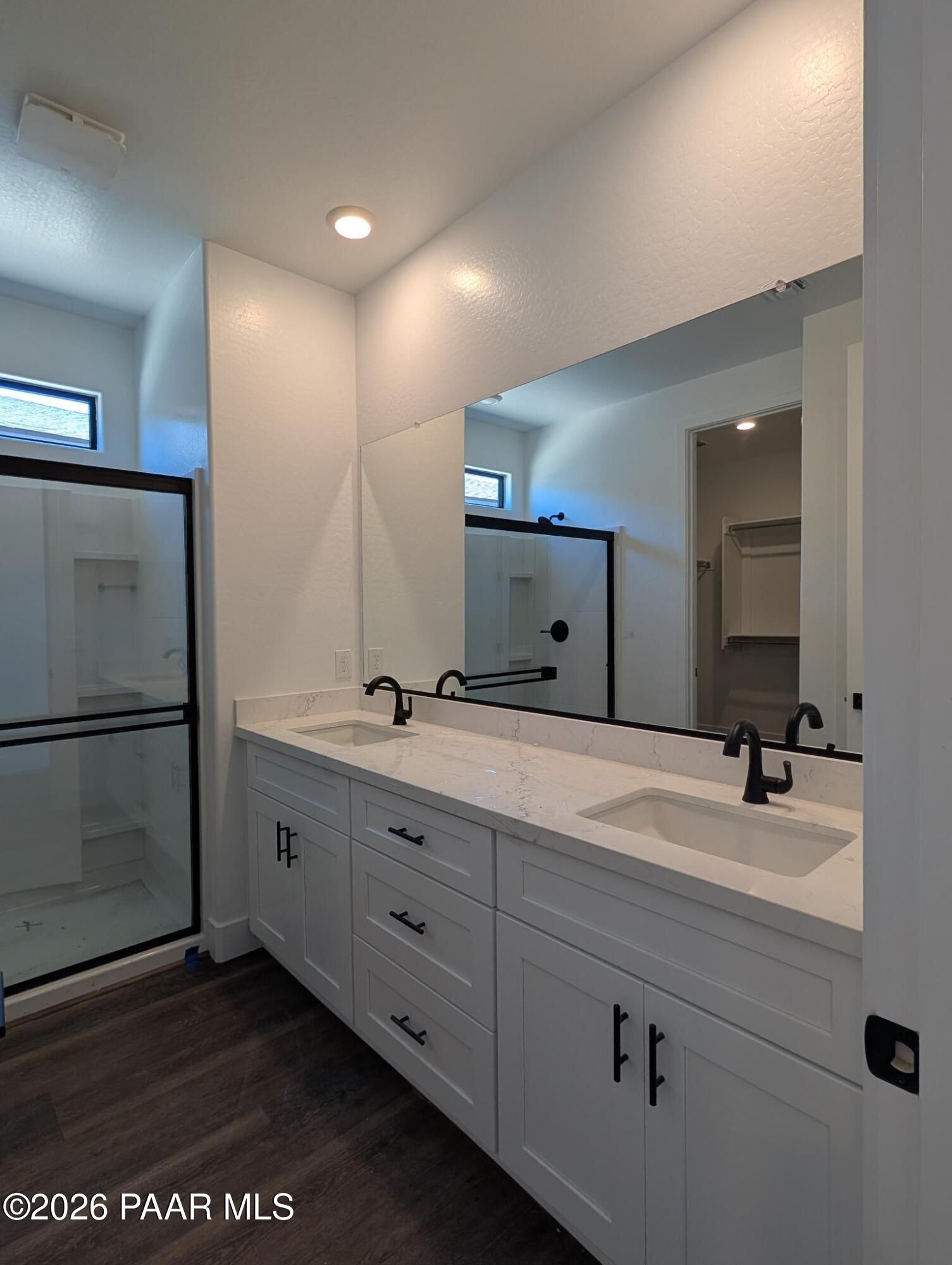 Modern bathroom with dual vanity, quartz countertops, and walk-in shower in The Durango II G at South Ranch, Prescott.