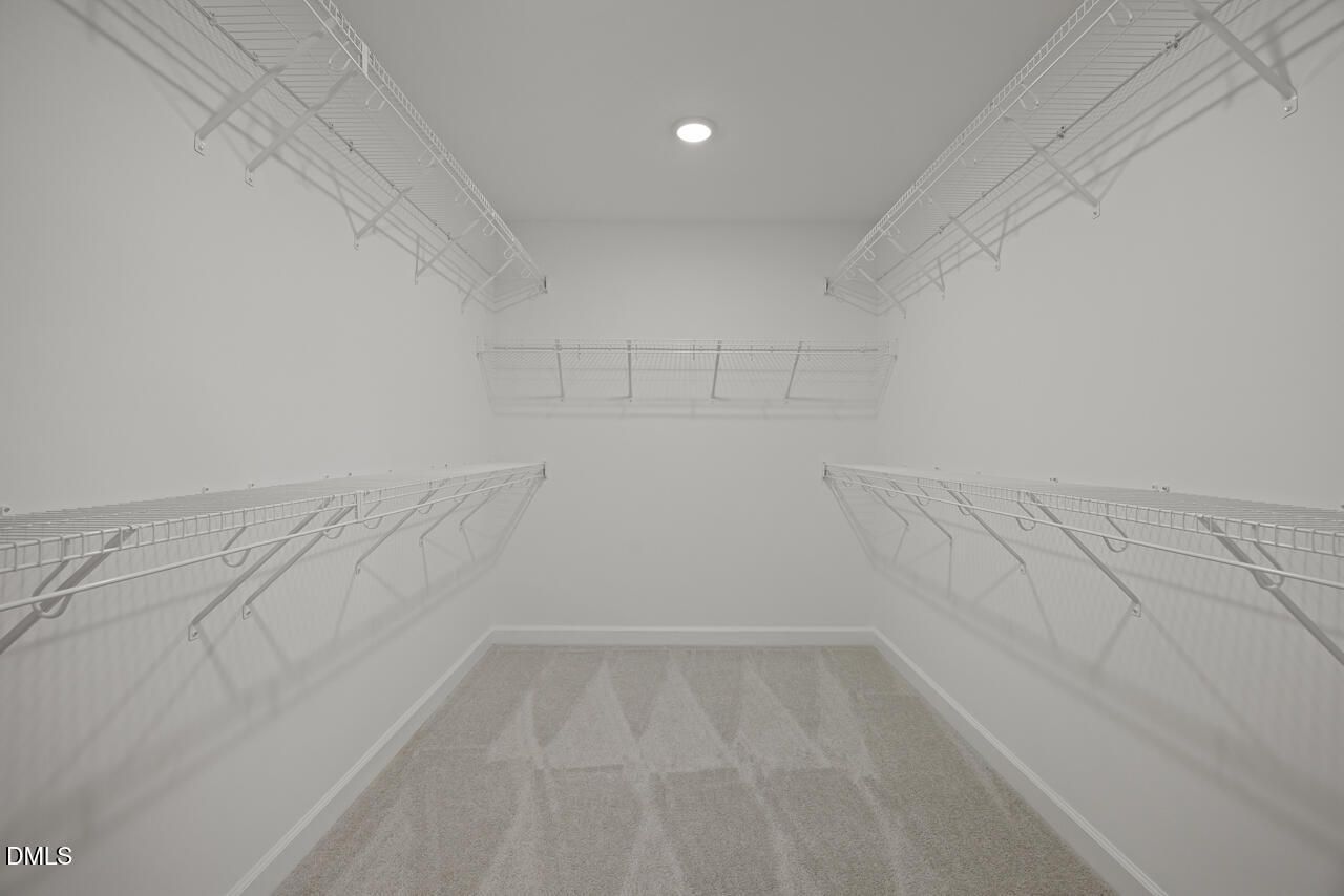 Walk-in closet with white wire shelving in The Chestnut floor plan at Wendell Ridge, Wendell, North Carolina.