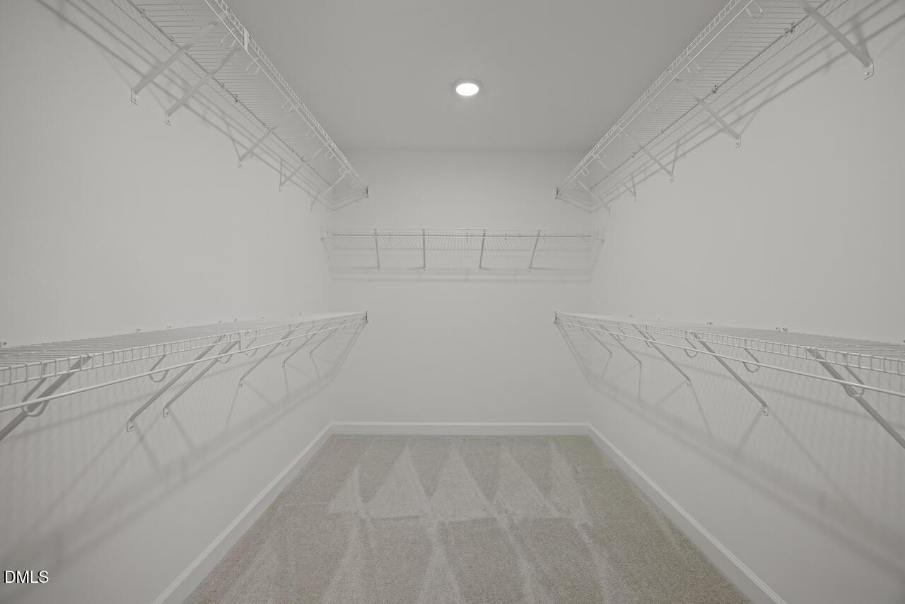 Walk-in closet with white wire shelving in The Chestnut floor plan at Wendell Ridge, Wendell, North Carolina.