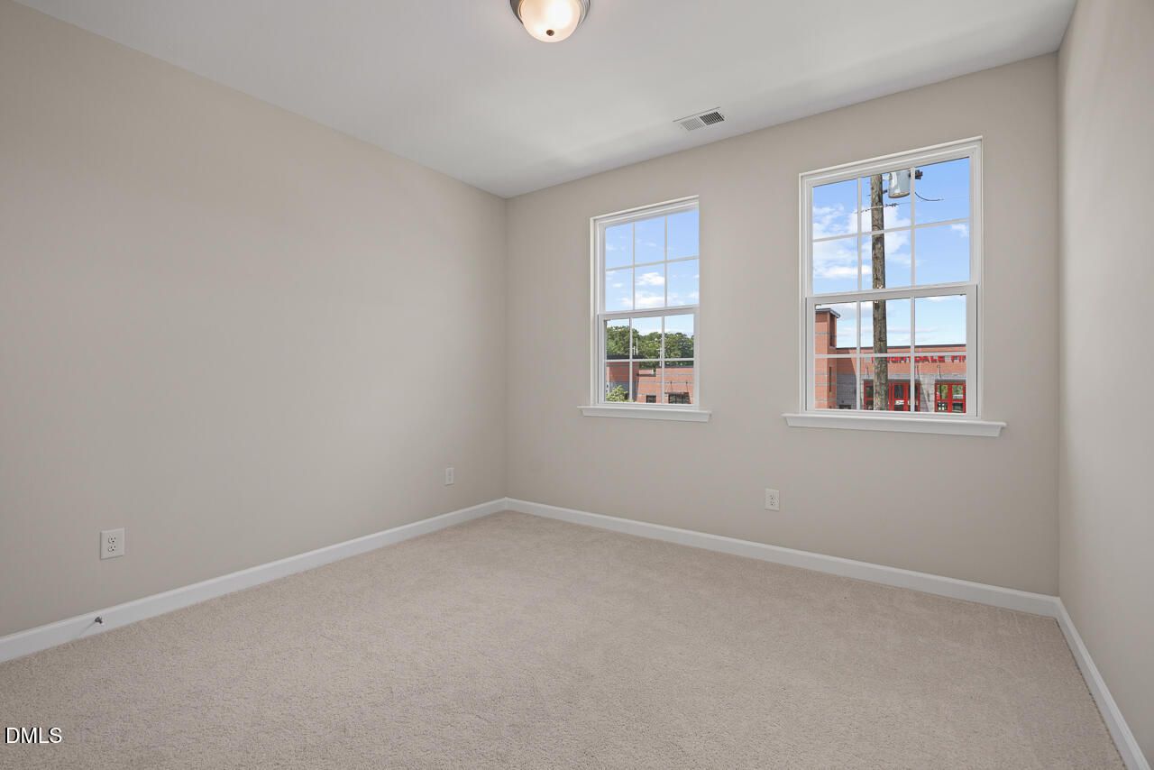 Bright, carpeted secondary bedroom in The Alexander C floor plan by Davidson Homes at Forestville Yard, Knightdale, NC.