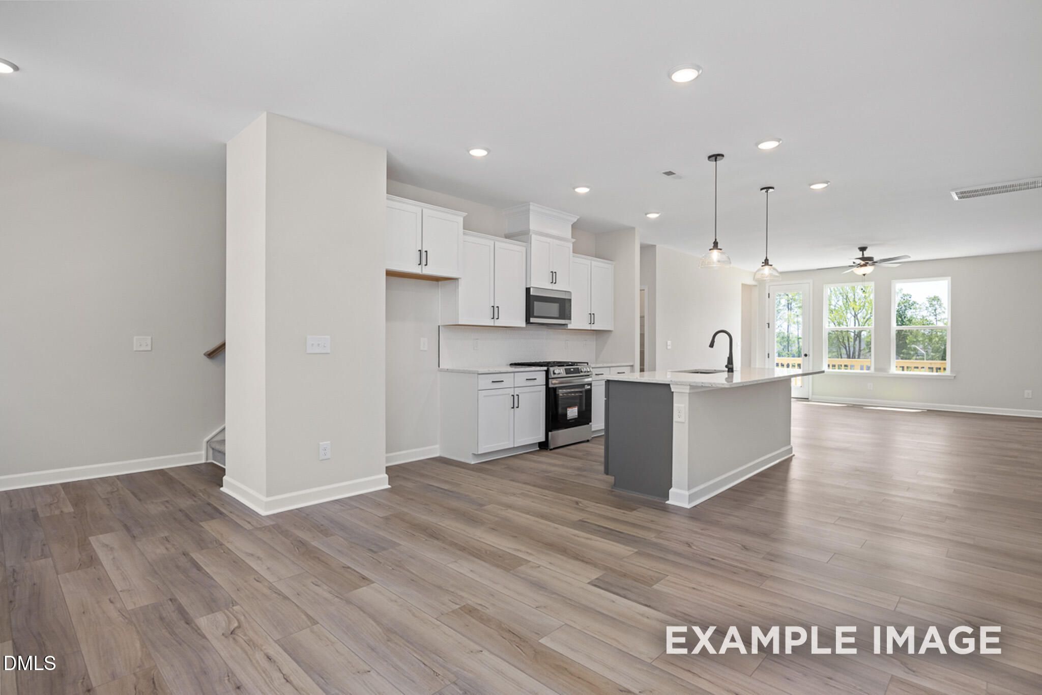 Modern open-concept kitchen with white cabinets and center island in The Mitchell floor plan at Camden Park, Knightdale.