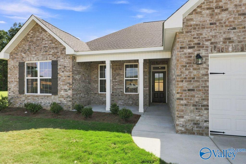 Brick exterior with covered front porch and 2-car garage at The Rockford, a Davidson Homes new construction in Cain Park, Hartselle, Alabama