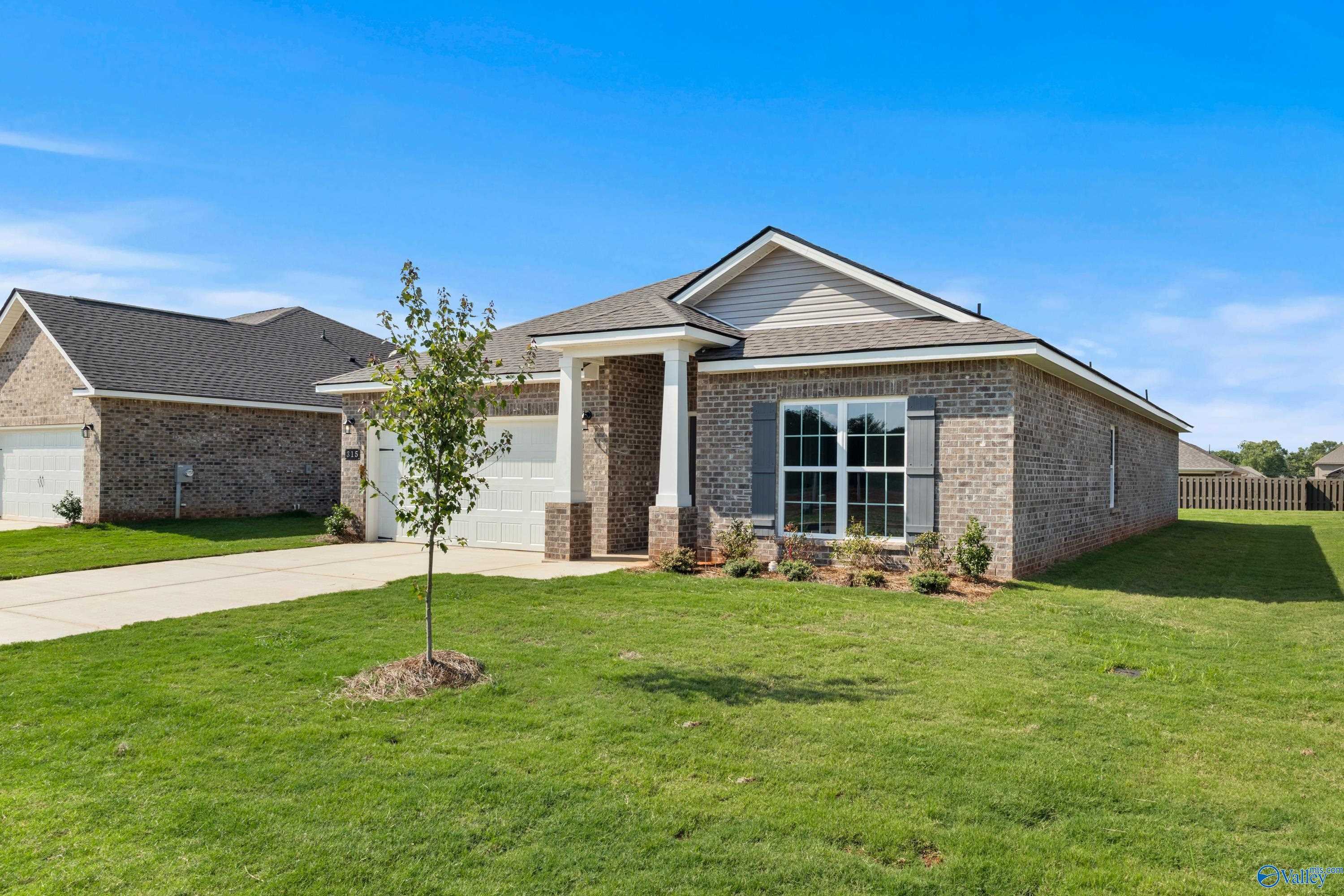 Modern 1-story brick home with 2-car garage, large windows, and lush front lawn in Clearview, Hazel Green, Alabama - Davidson Homes The Daphne
