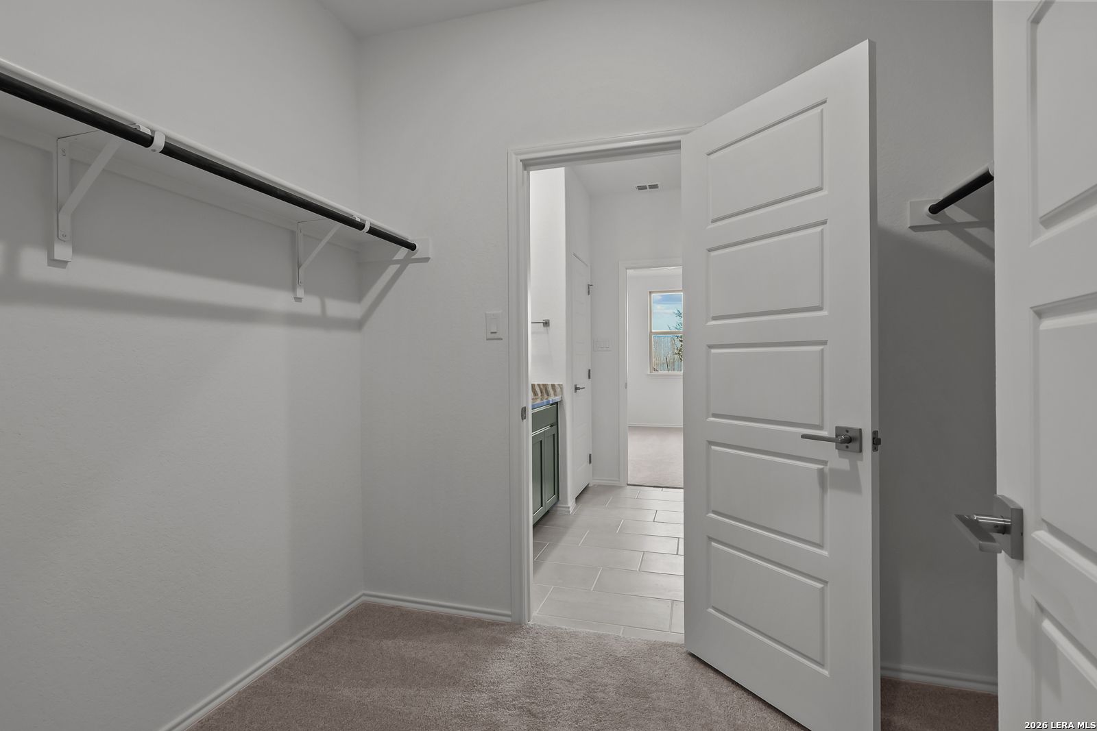 Walk-in closet with carpet and shelving in the Brazos B floor plan by Davidson Homes in Agave, San Antonio, Texas.