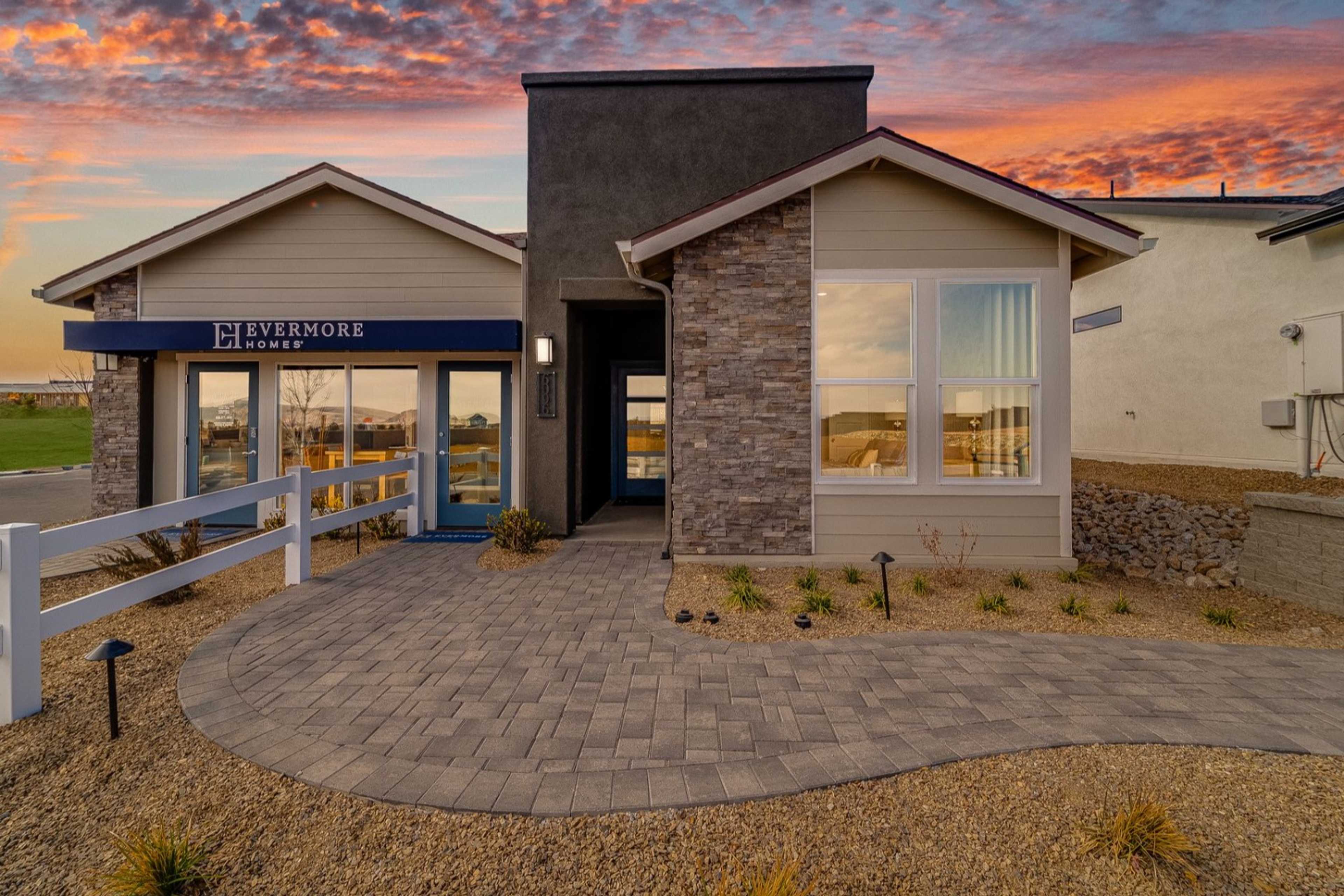 Modern Silverstone model home exterior at South Ranch in Prescott AZ with stone facade, large windows, and desert pathway