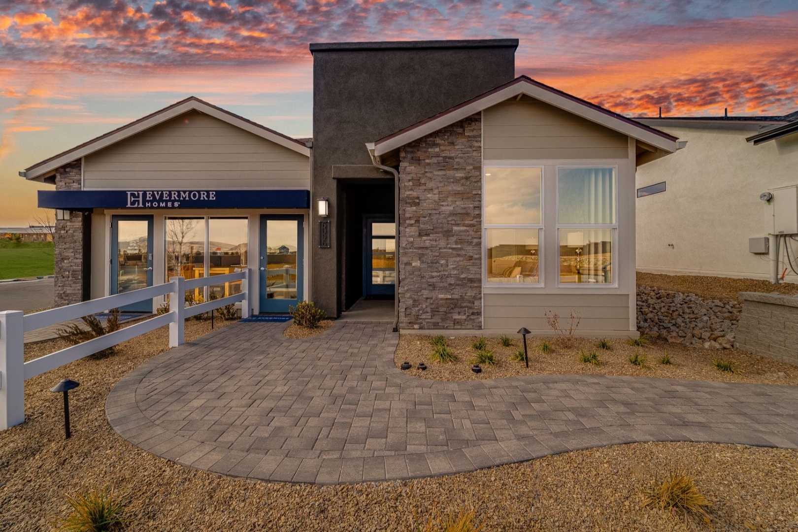 Modern Silverstone model home exterior at South Ranch in Prescott AZ with stone facade, large windows, and desert pathway