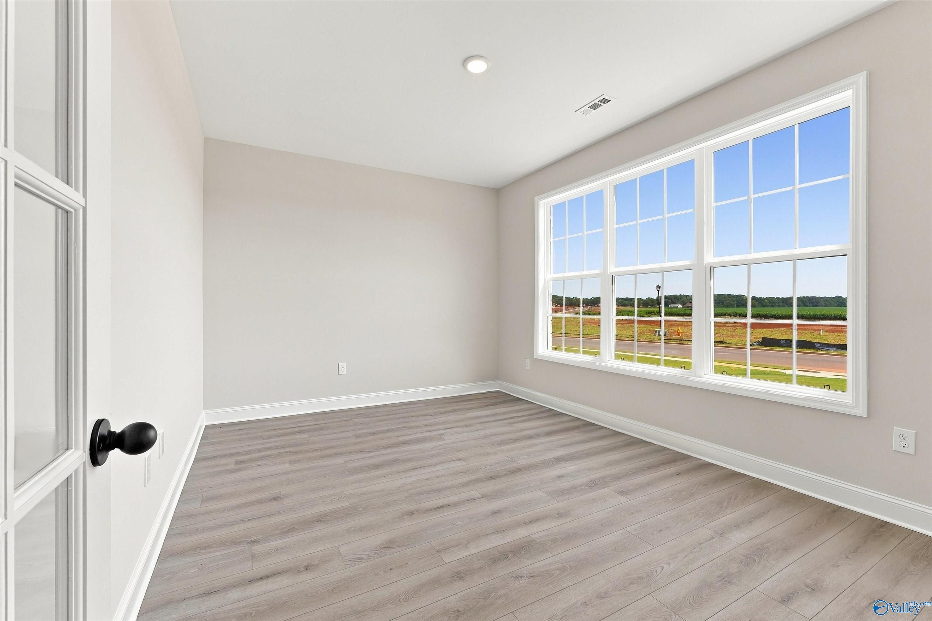 Bright, spacious flex room with wood-look flooring and large windows in The Oxford floor plan, Kendall Farms, Toney, AL.
