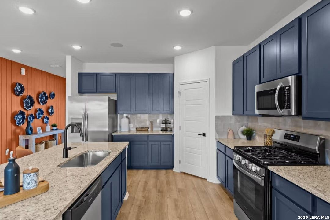 Modern navy blue kitchen with granite island, stainless appliances in Davidson Homes Douglas C, Converse Texas