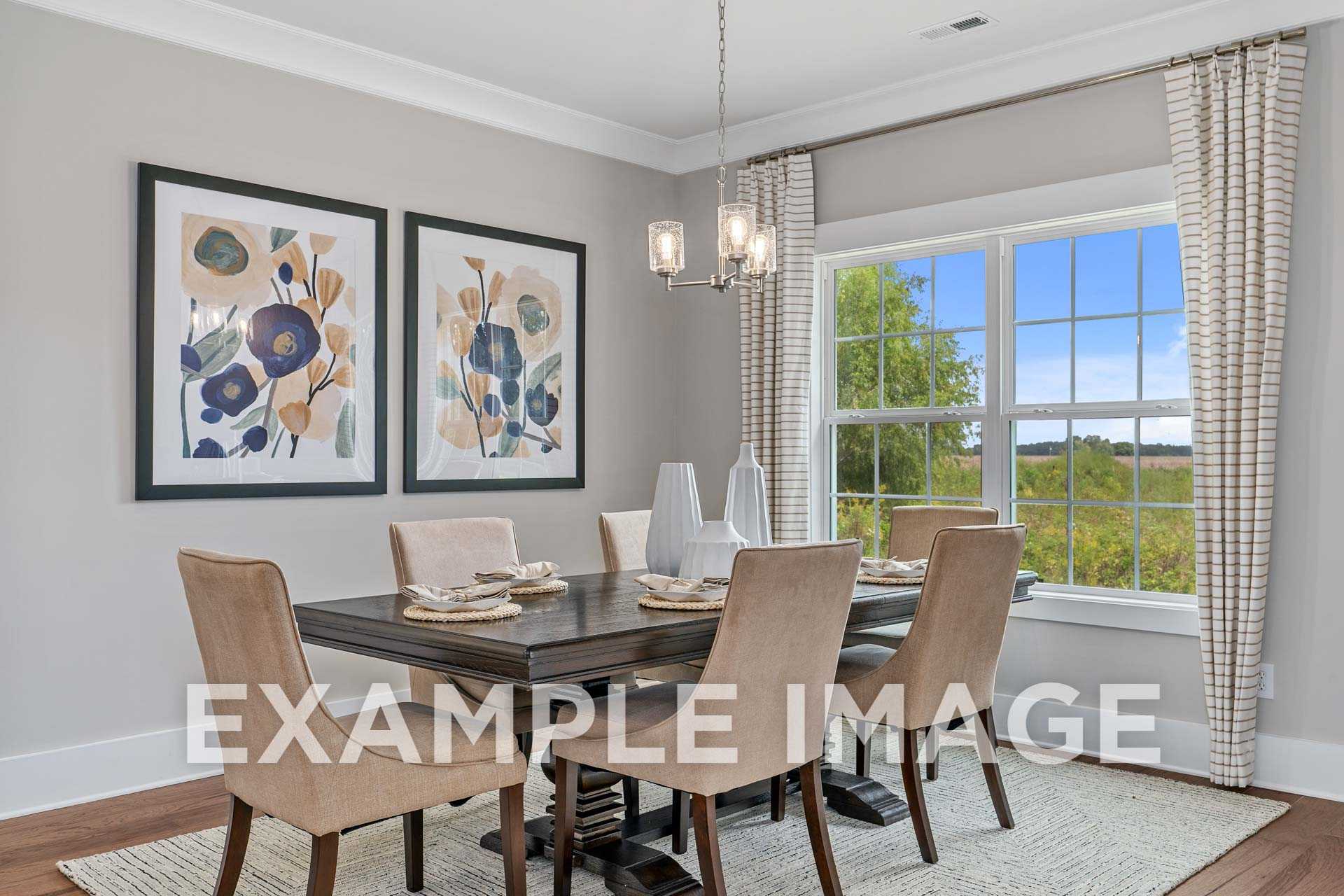 Dining room in The Harrison home with wooden table, upholstered chairs, chandelier, and tree-view windows