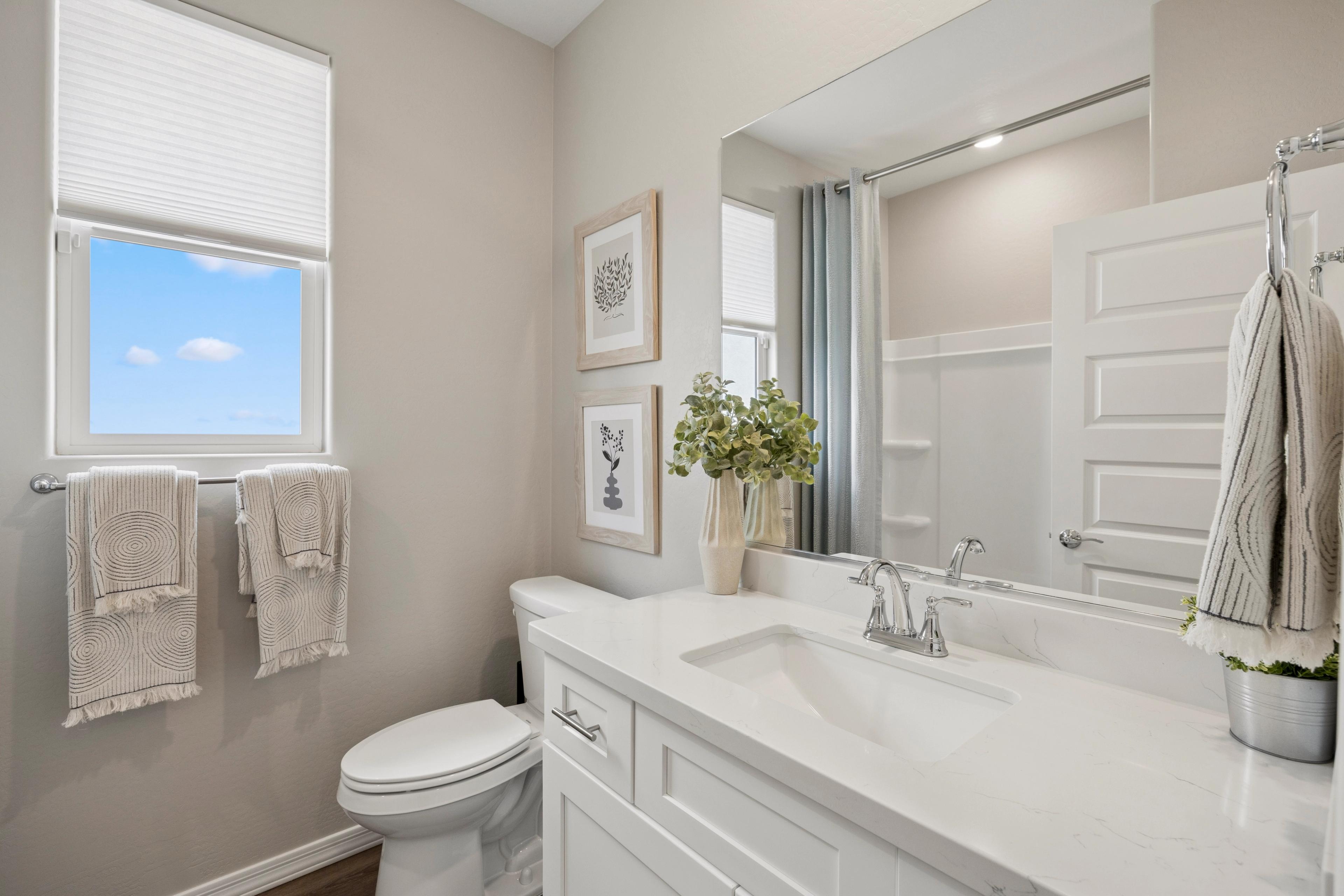 Bright bathroom at South Ranch Destination Collection in Prescott AZ with white quartz vanity, large mirror, walk-in shower