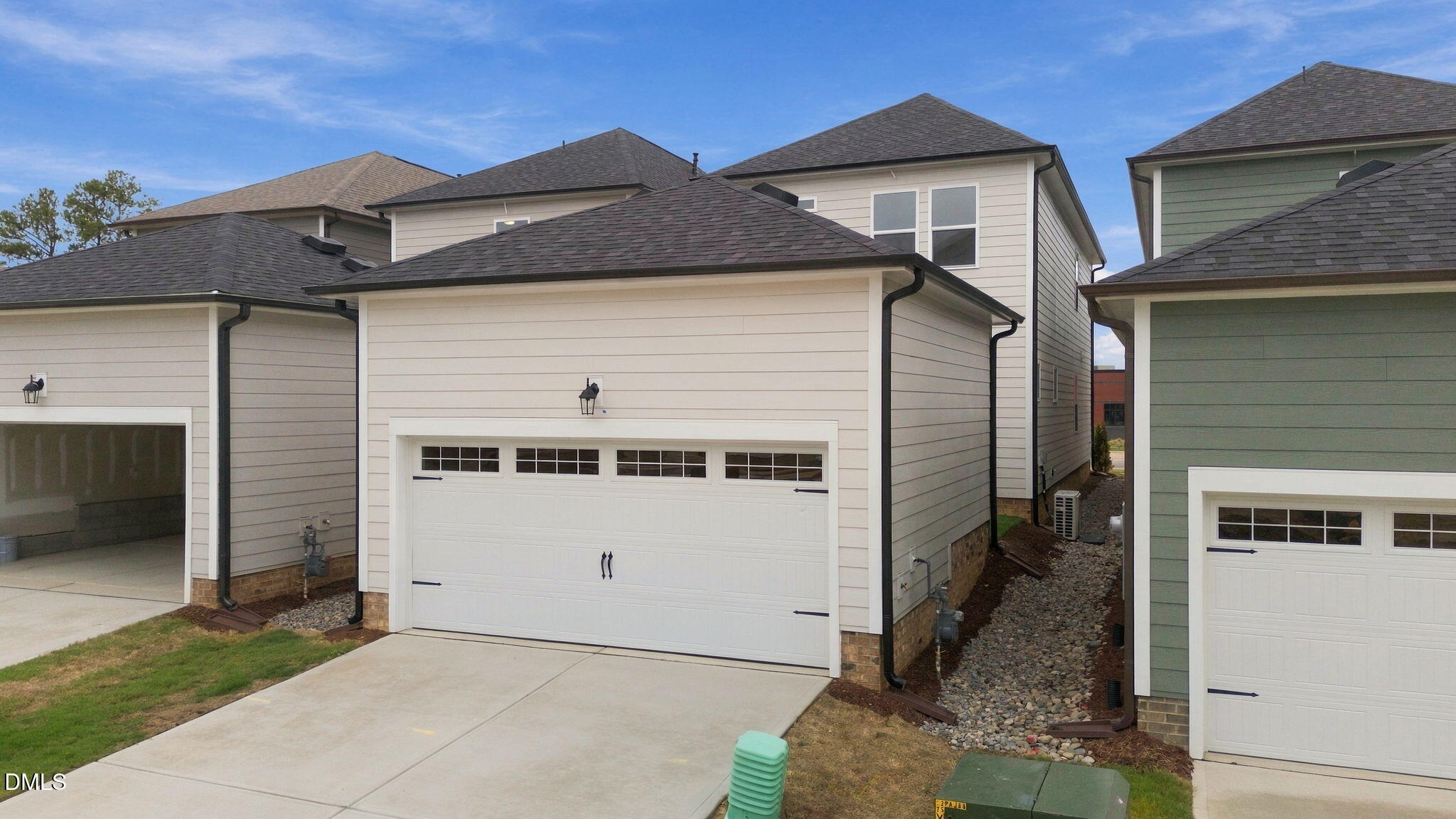 Two-car garage with white carriage-style doors on 2-story Davidson Homes The Alexander B in Forestville Yard, Knightdale NC