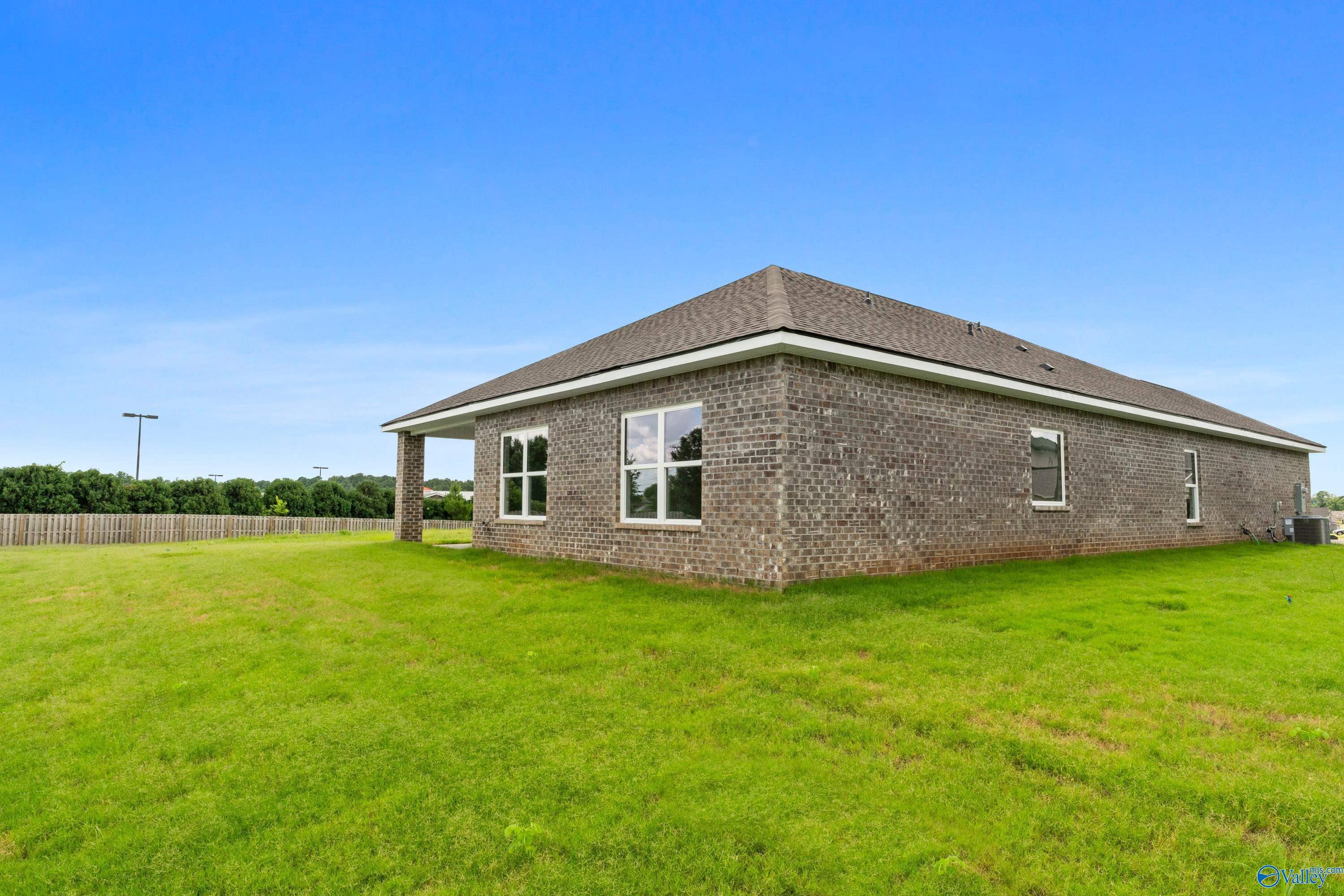 Back exterior view of The Everett B floor plan home by Davidson Homes in The Meadows, Athens, Alabama with large yard.