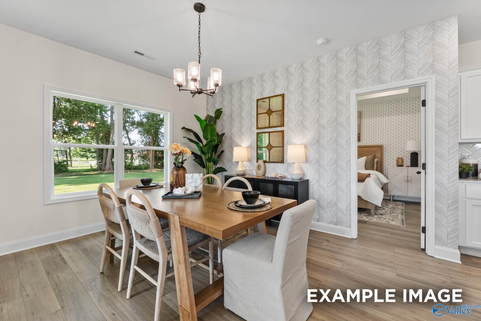 Elegant dining room with wooden table, chandelier, potted plants, and window views in Davidson Homes The Franklin, Huntsville, AL