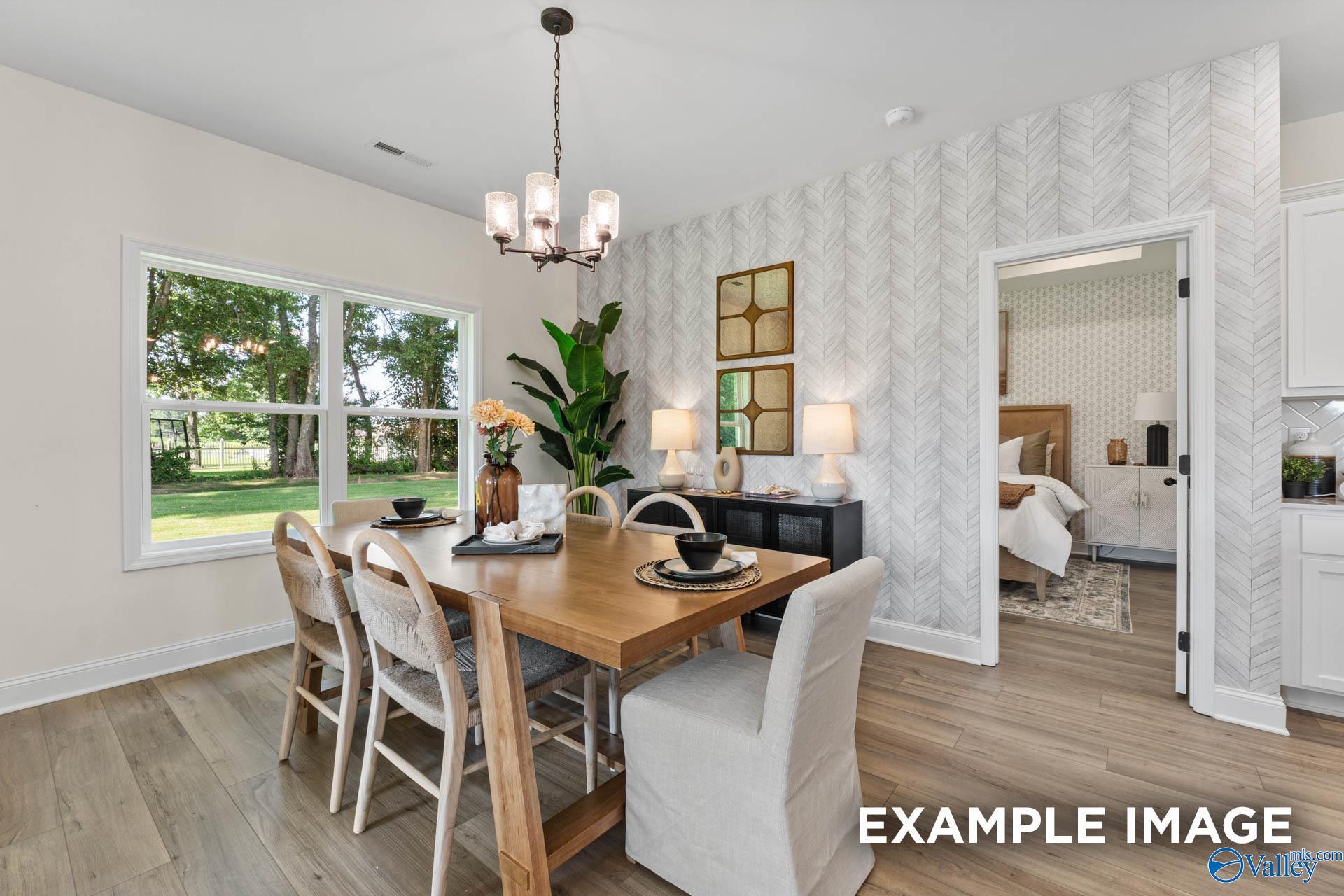 Modern dining room with herringbone wallpaper and wood table in The Franklin floor plan by Davidson Homes, Huntsville.
