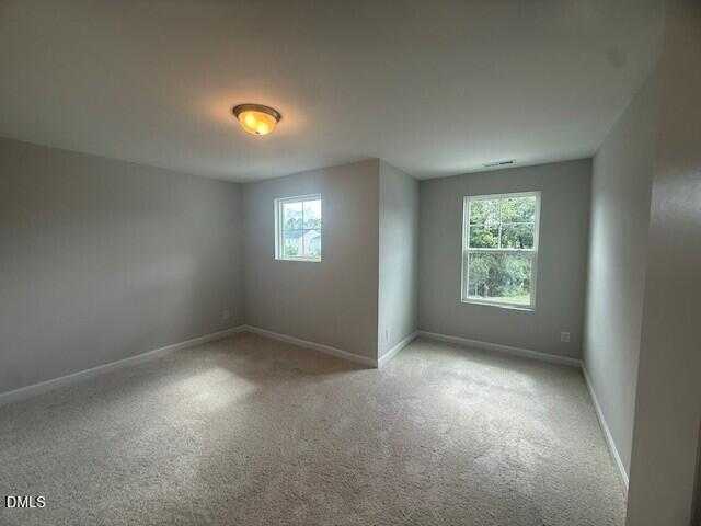 Bright secondary bedroom with light gray walls, double windows, and beige carpet in The Preston C by Davidson Homes, Lillington, NC