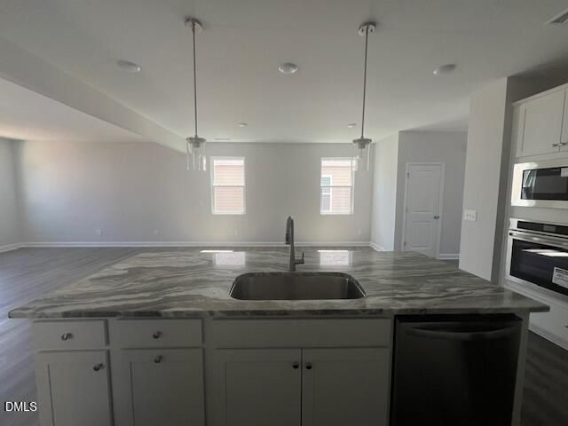 Modern open-concept kitchen with veined quartz island, stainless sink, white cabinets, and appliances in Davidson Homes Adalynn A, Lillington NC