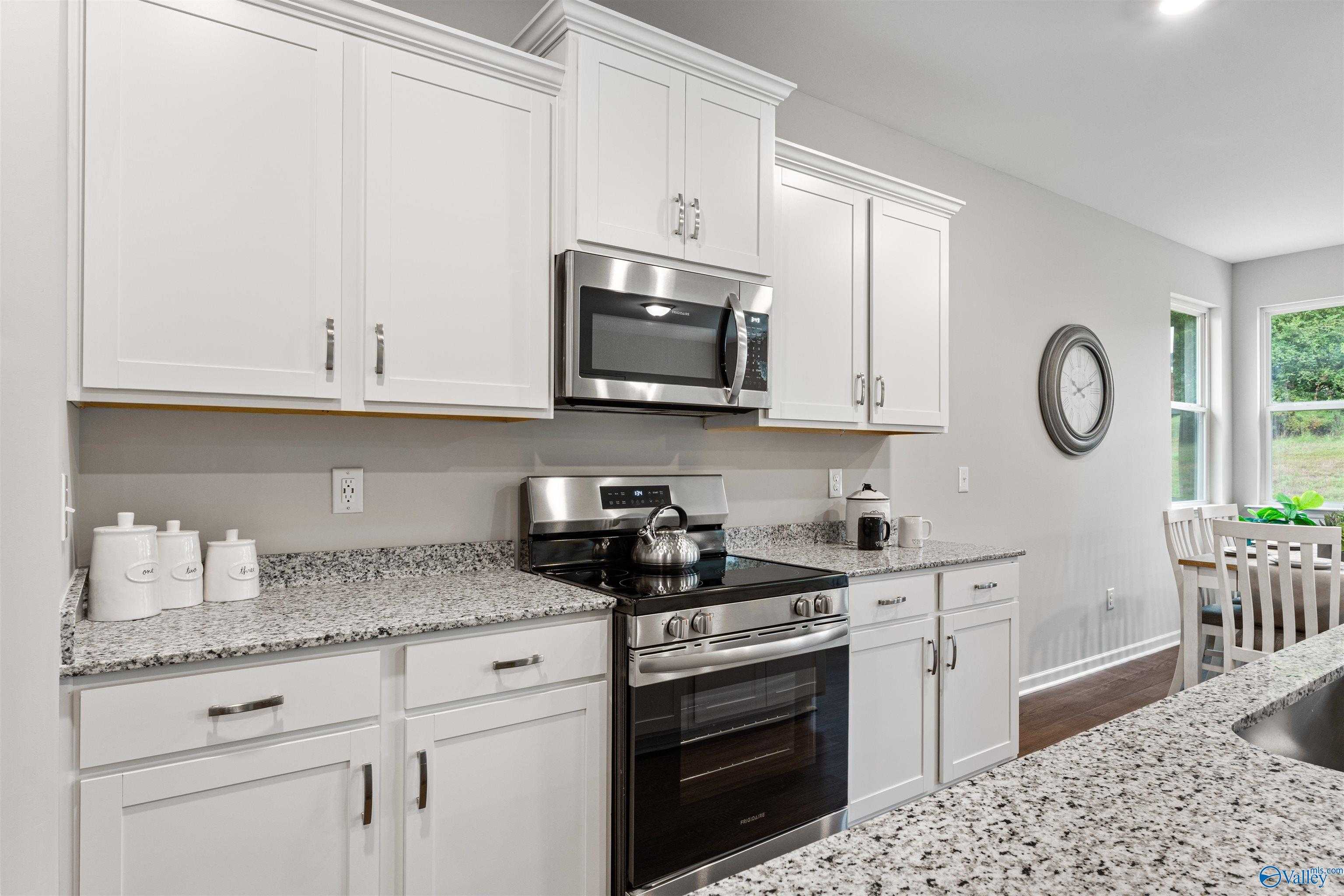 Modern kitchen with white shaker cabinets, granite countertops, stainless steel appliances in Davidson Homes The Phoenix, Fayetteville TN