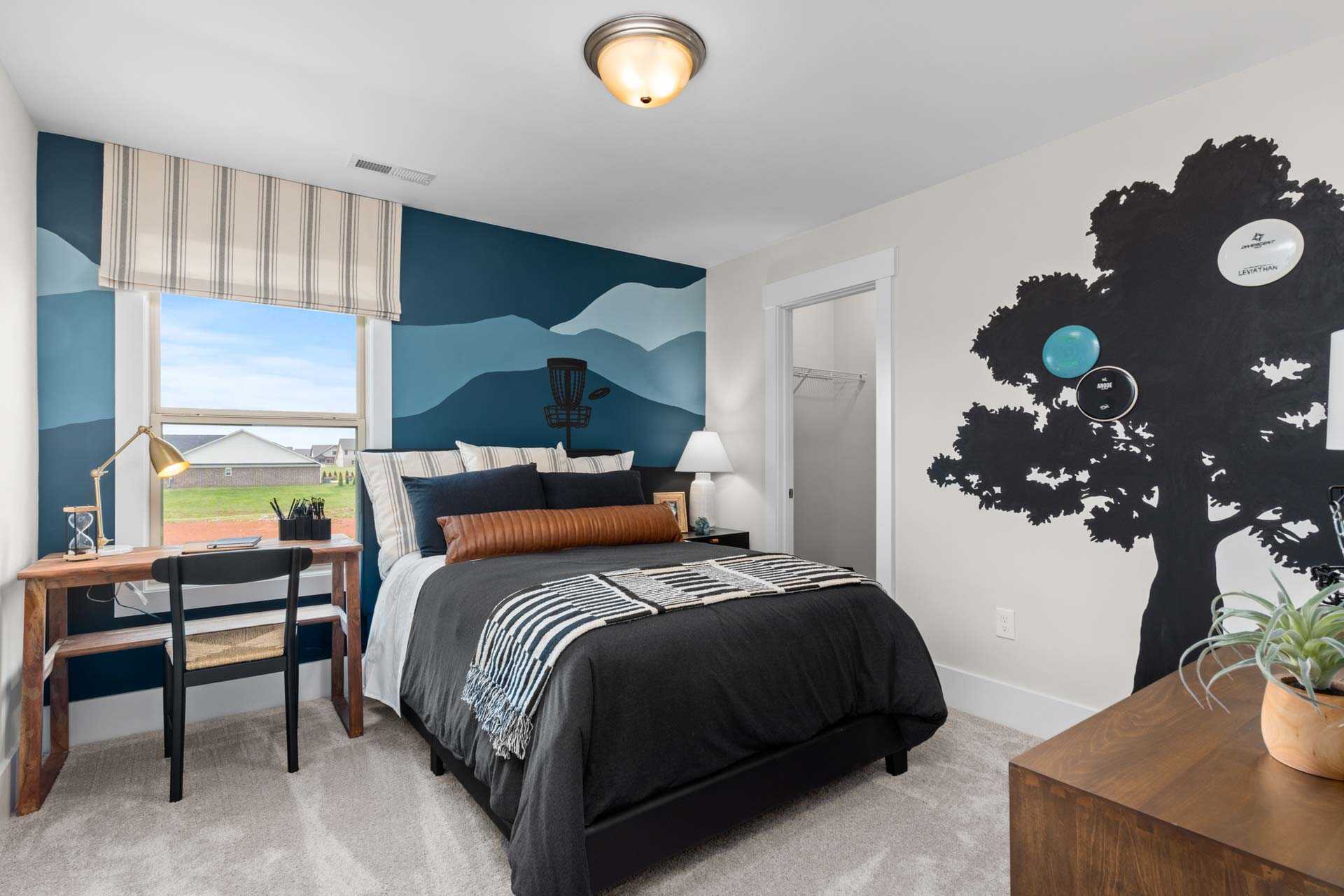 Cozy bedroom at Walker's Hill in Meridianville Alabama with navy mural mountains tree bed desk and window view